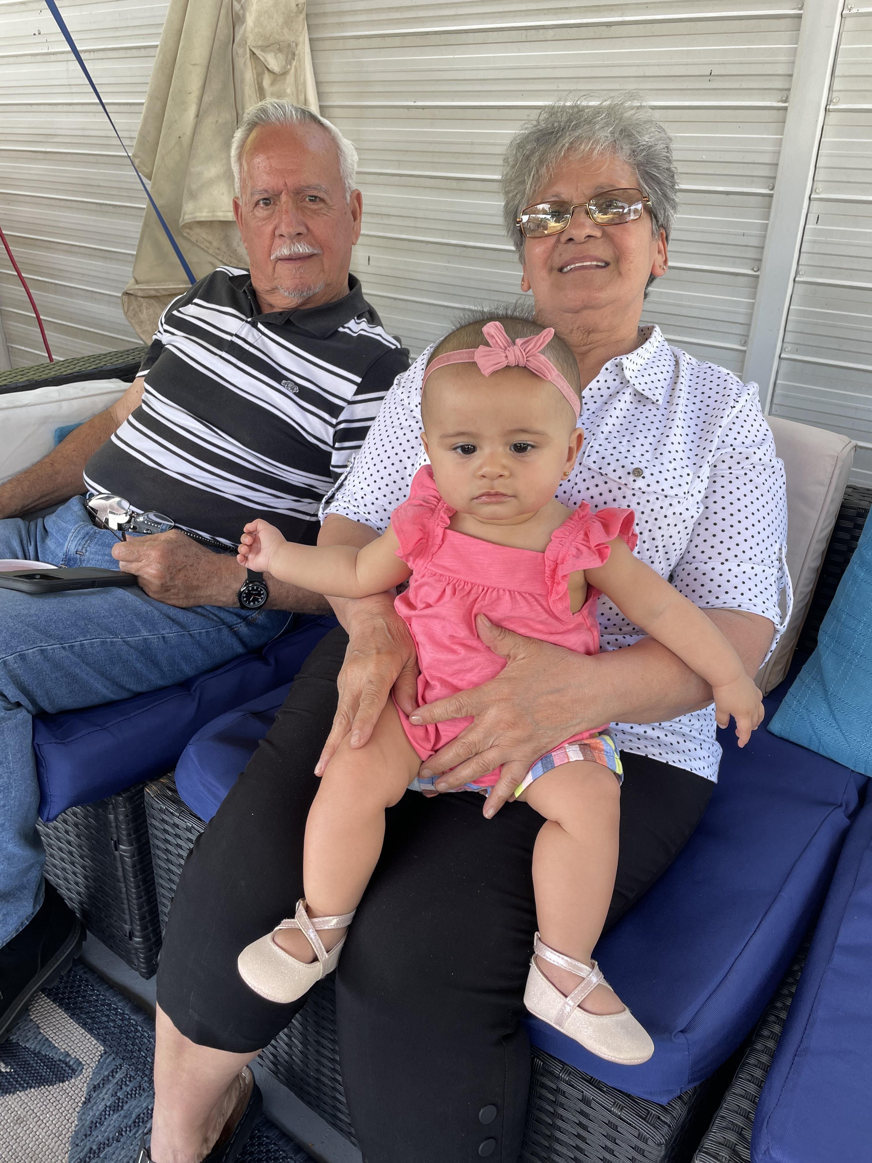 A man and woman sitting on a chair with a baby