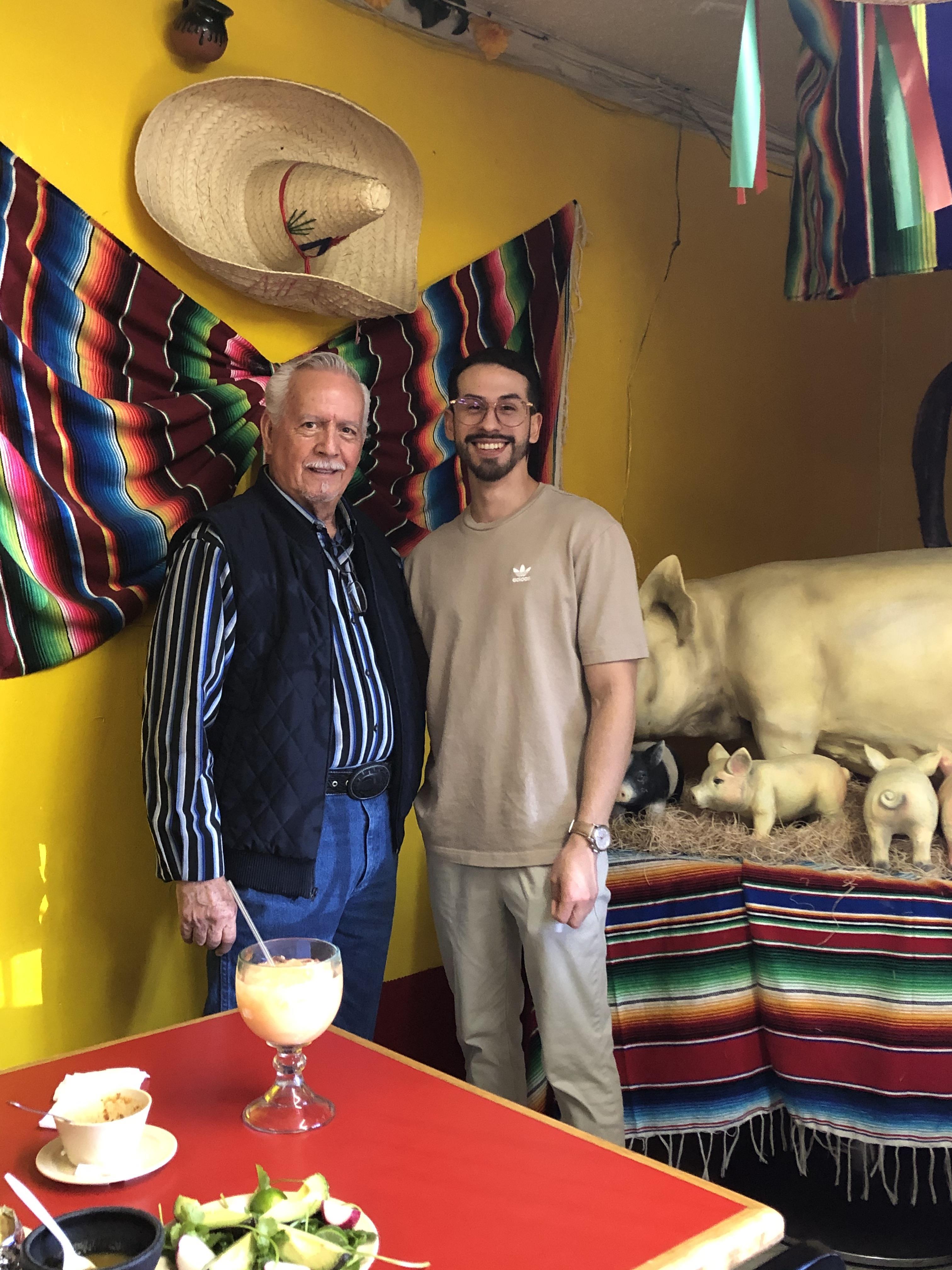 Two men standing next to a table