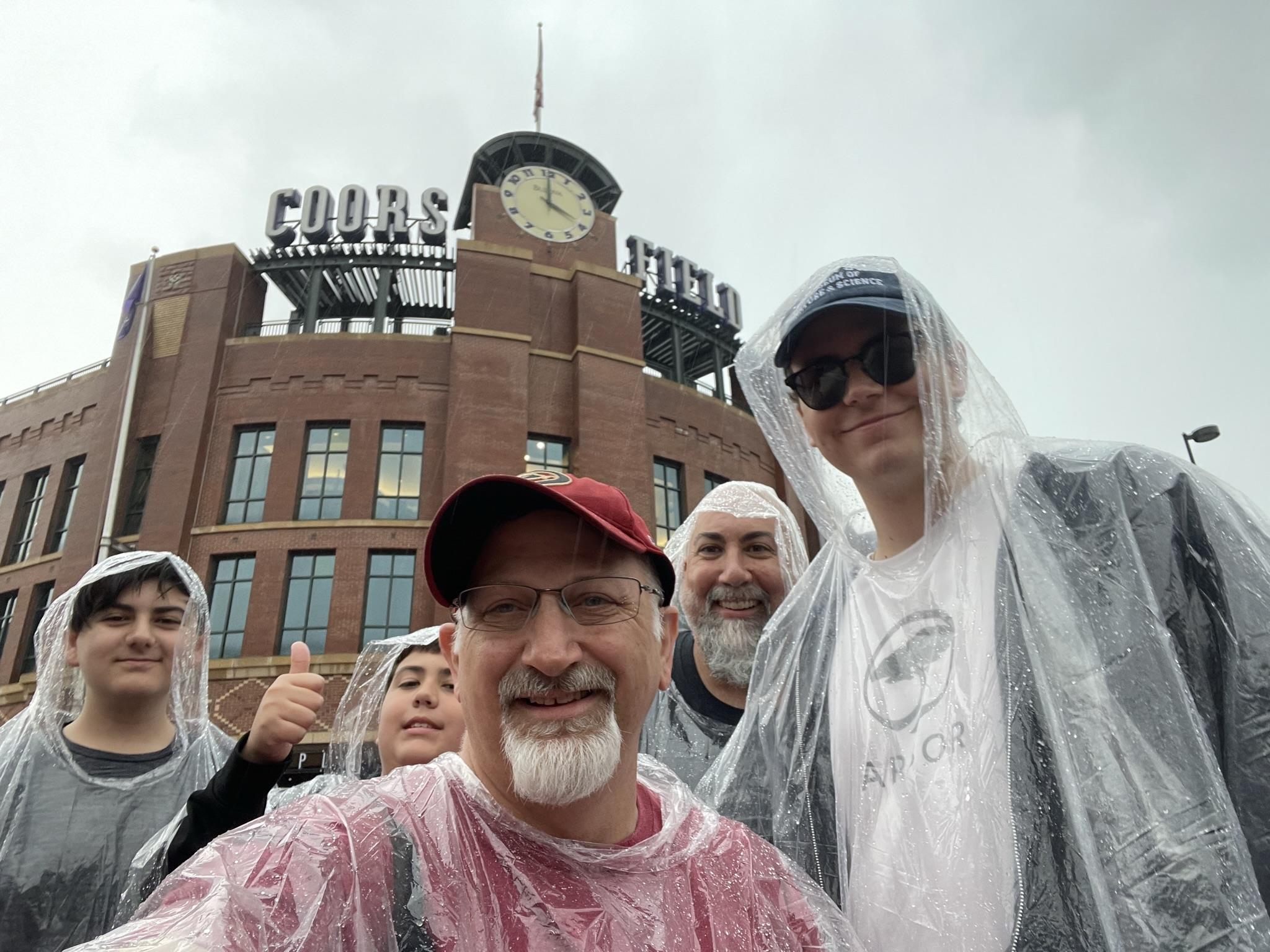A group of people wearing raincoats and standing in front of a building