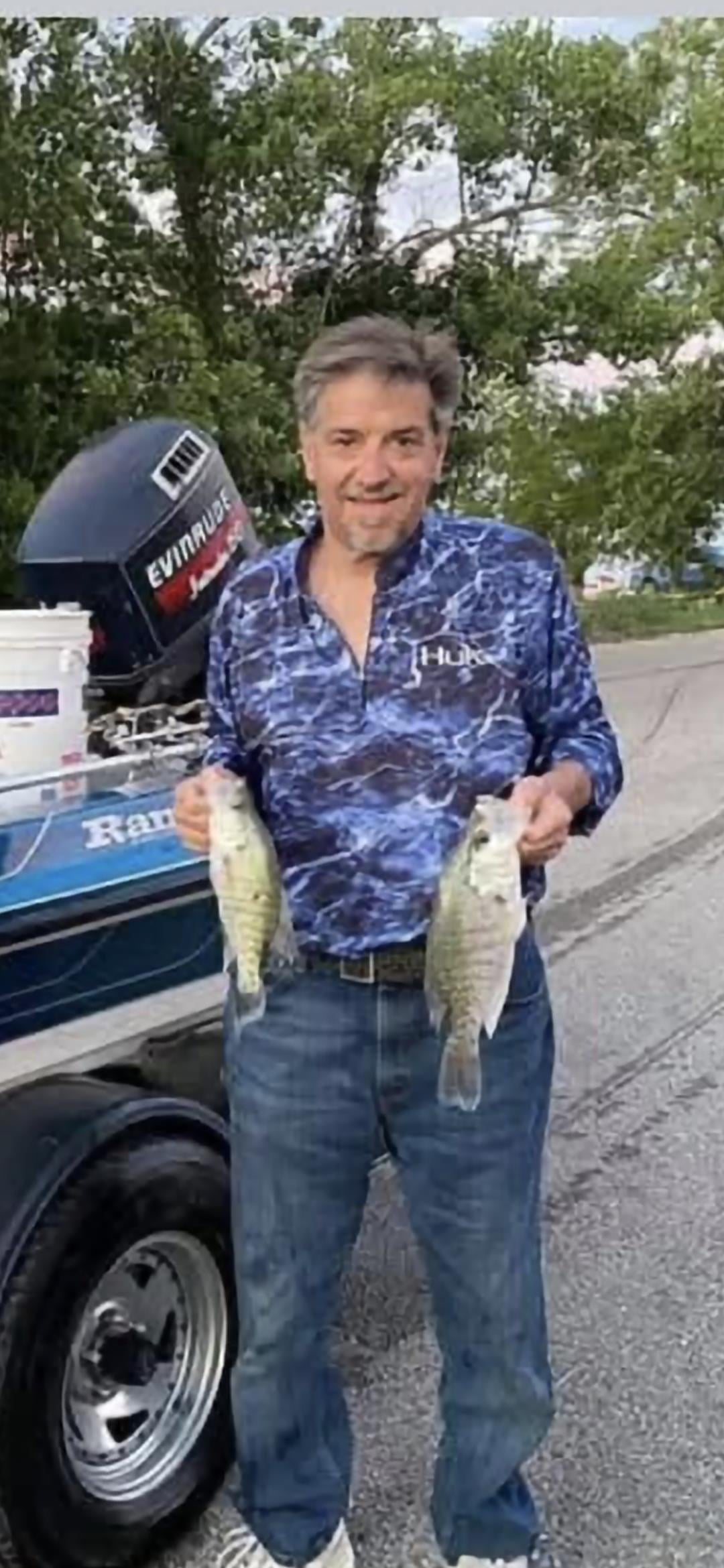 A man holding two fish