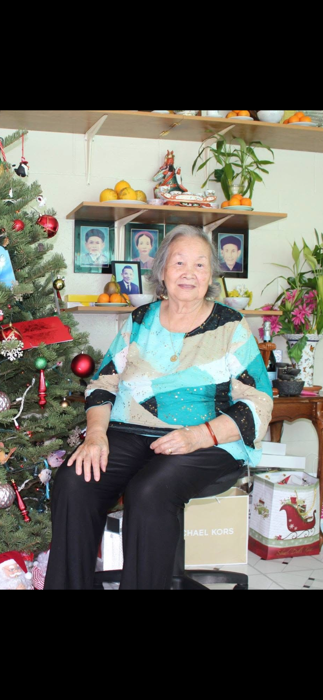 A woman sitting in front of a christmas tree