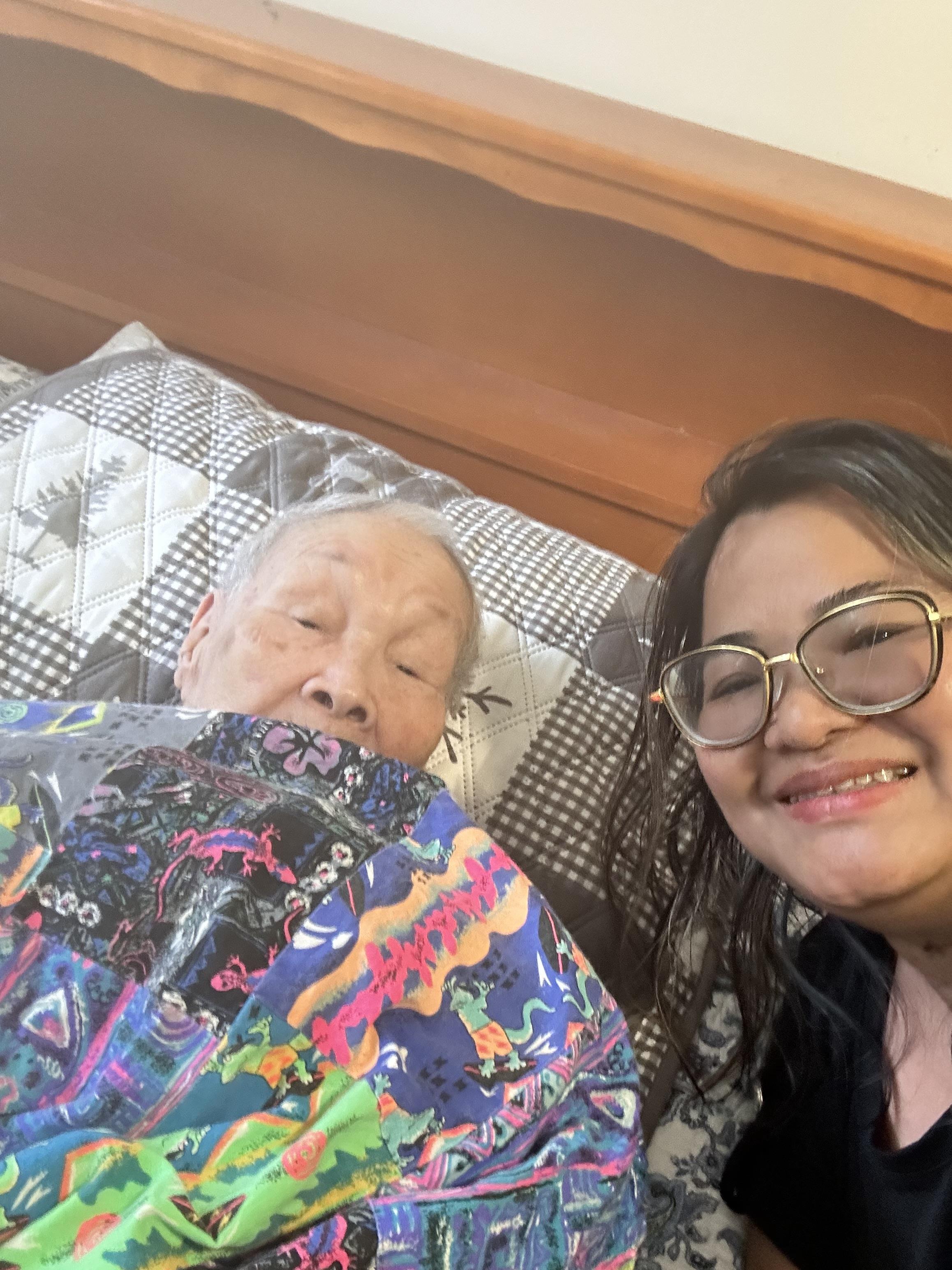 A woman holding an old man's blanket
