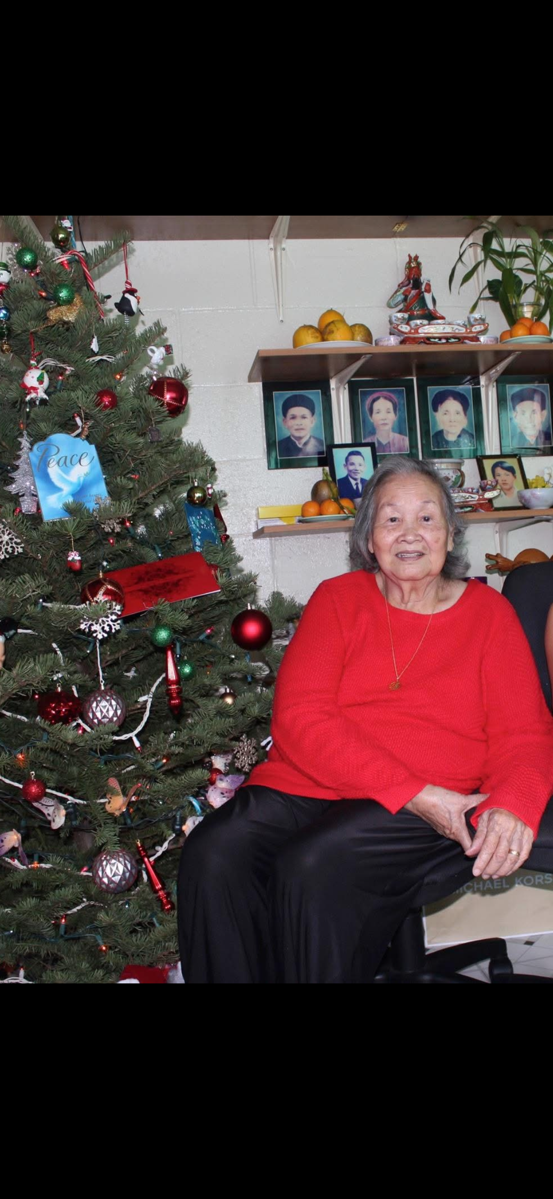 A woman sitting in front of a christmas tree