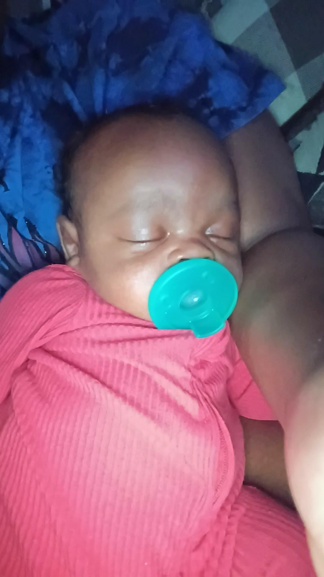 A baby sleeping with a pacifier