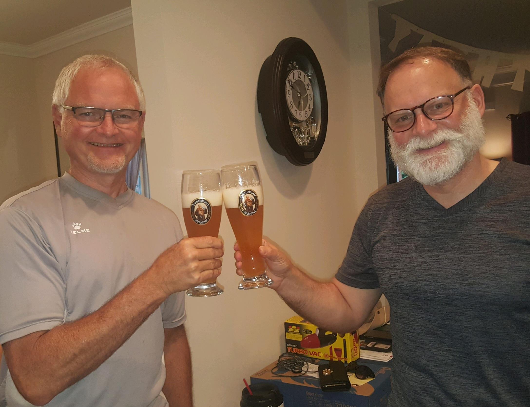 Two men holding up glasses of beer