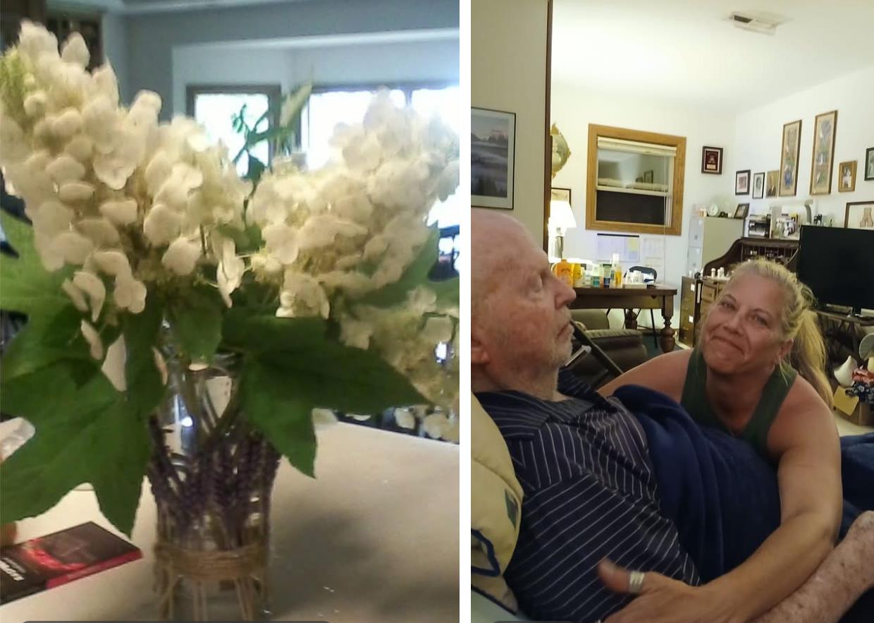 A man and woman sitting in a chair with flowers in a vase