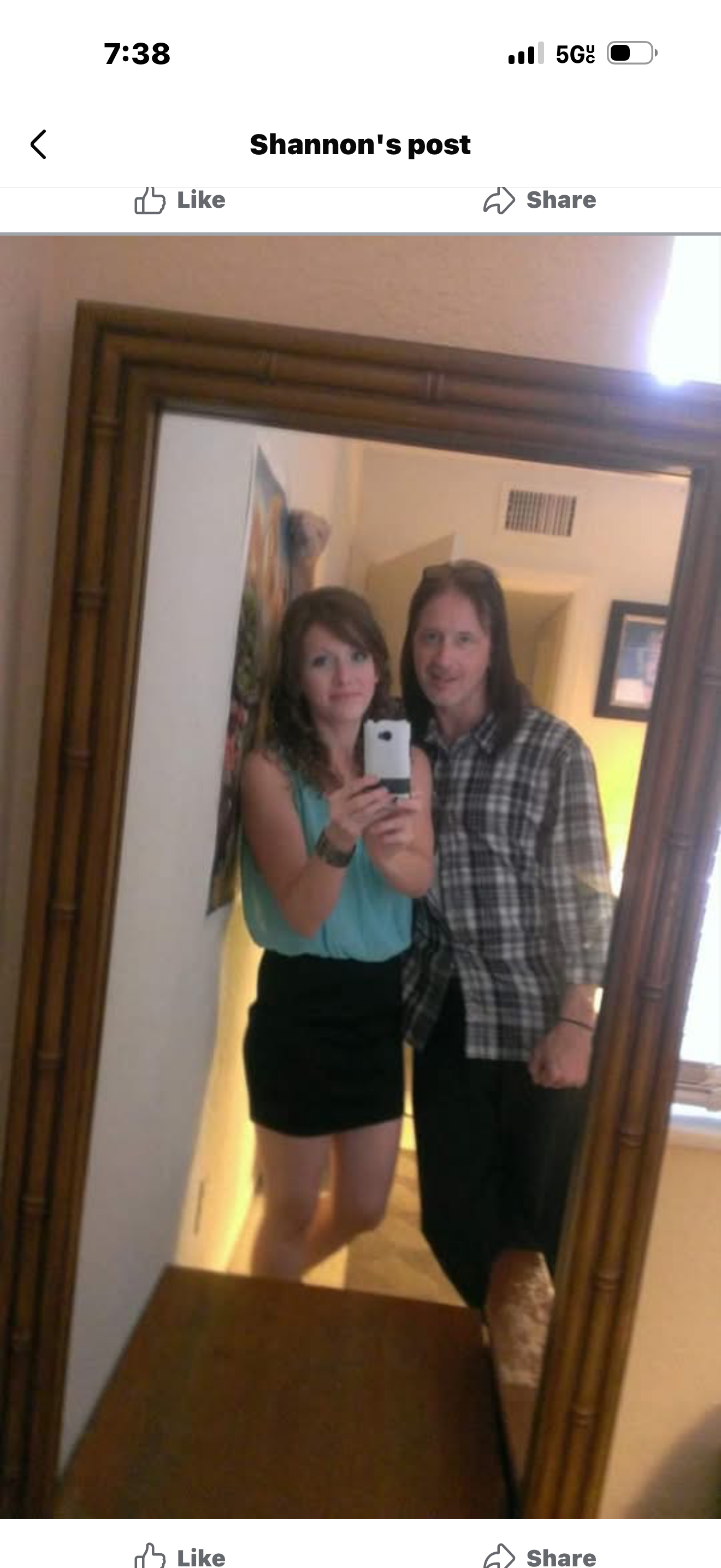 A man and woman taking a selfie in a mirror