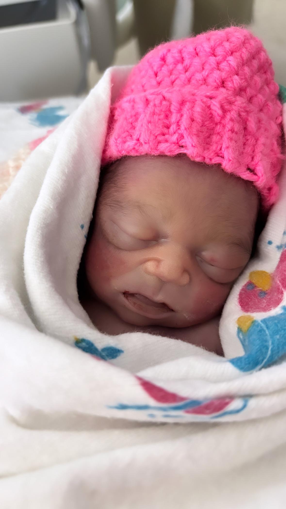 A baby in a pink hat