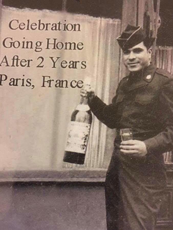 A man in uniform holding a bottle of wine