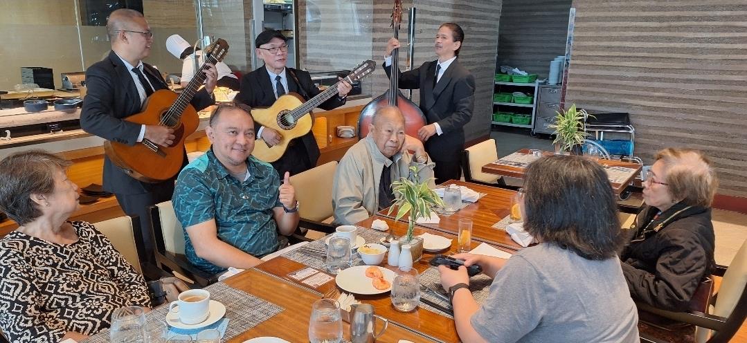 A group of people sitting at a table playing instruments