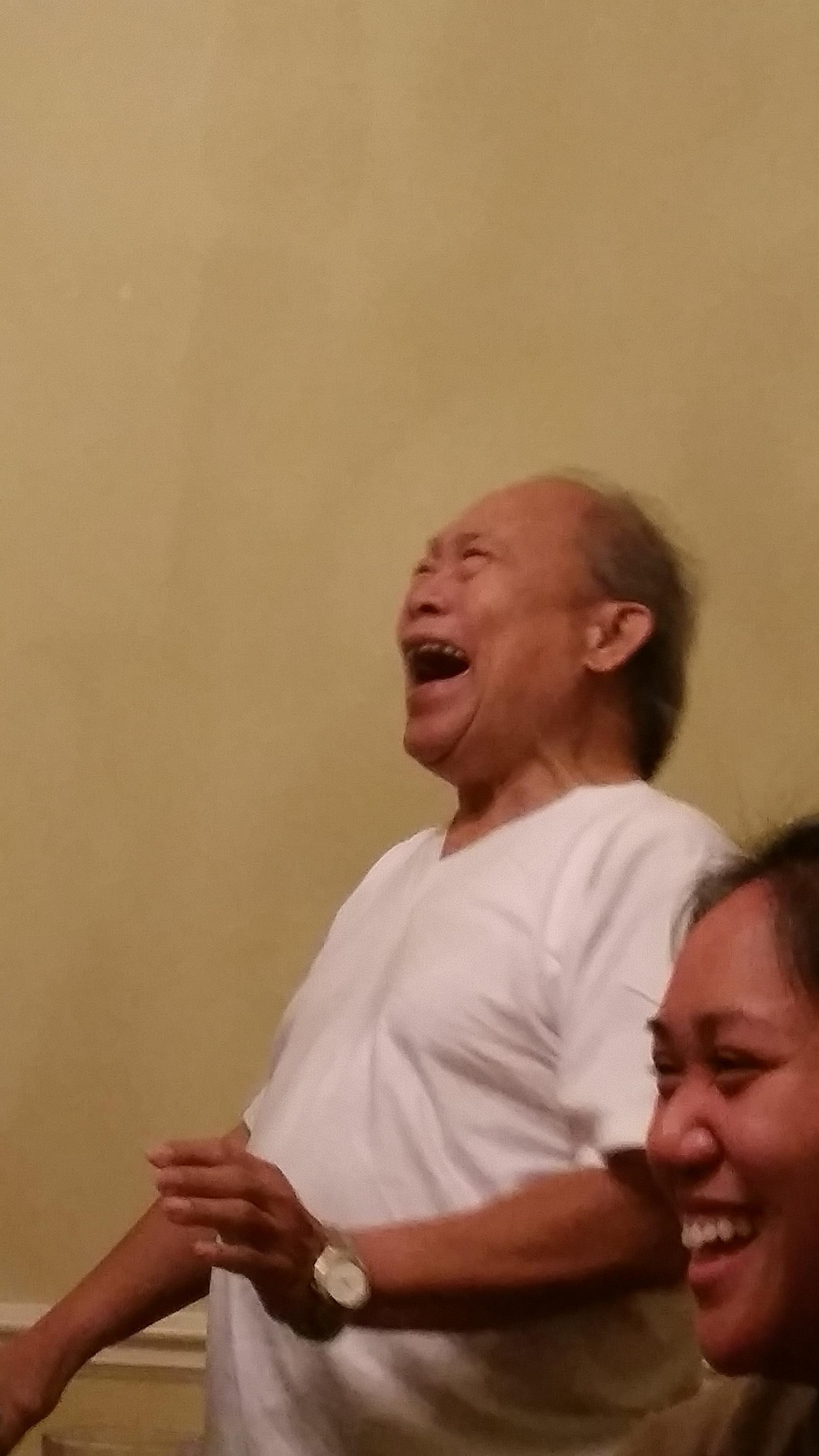 A man in a white shirt laughing