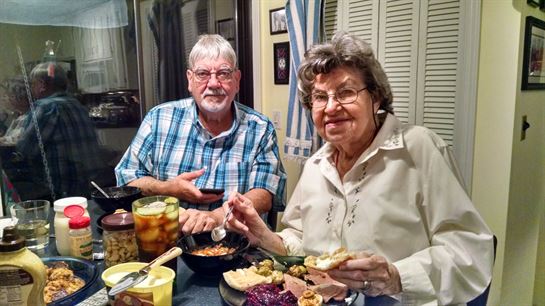 A man and woman sitting at a table eating food