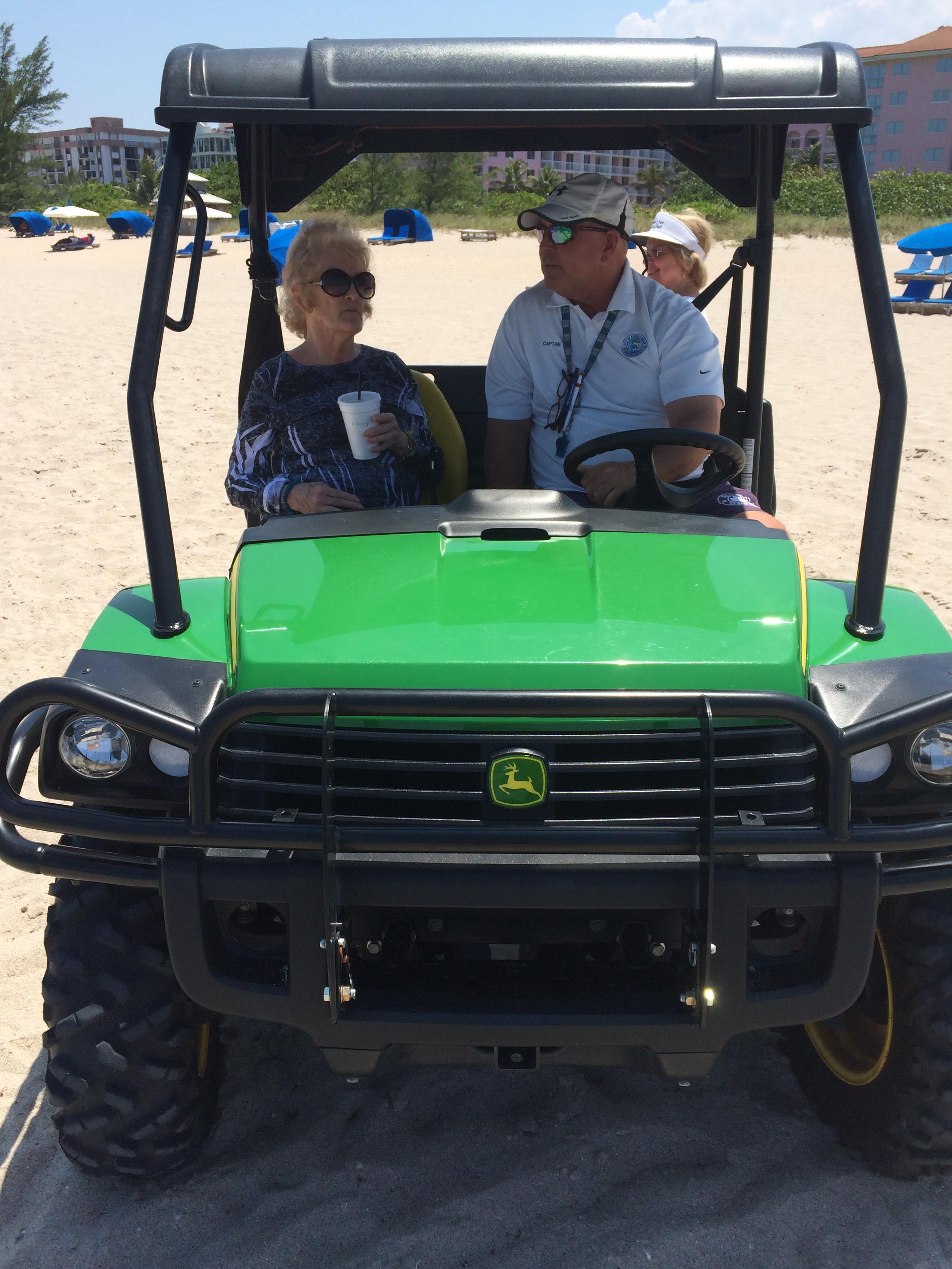 A group of people in a golf cart on a beach