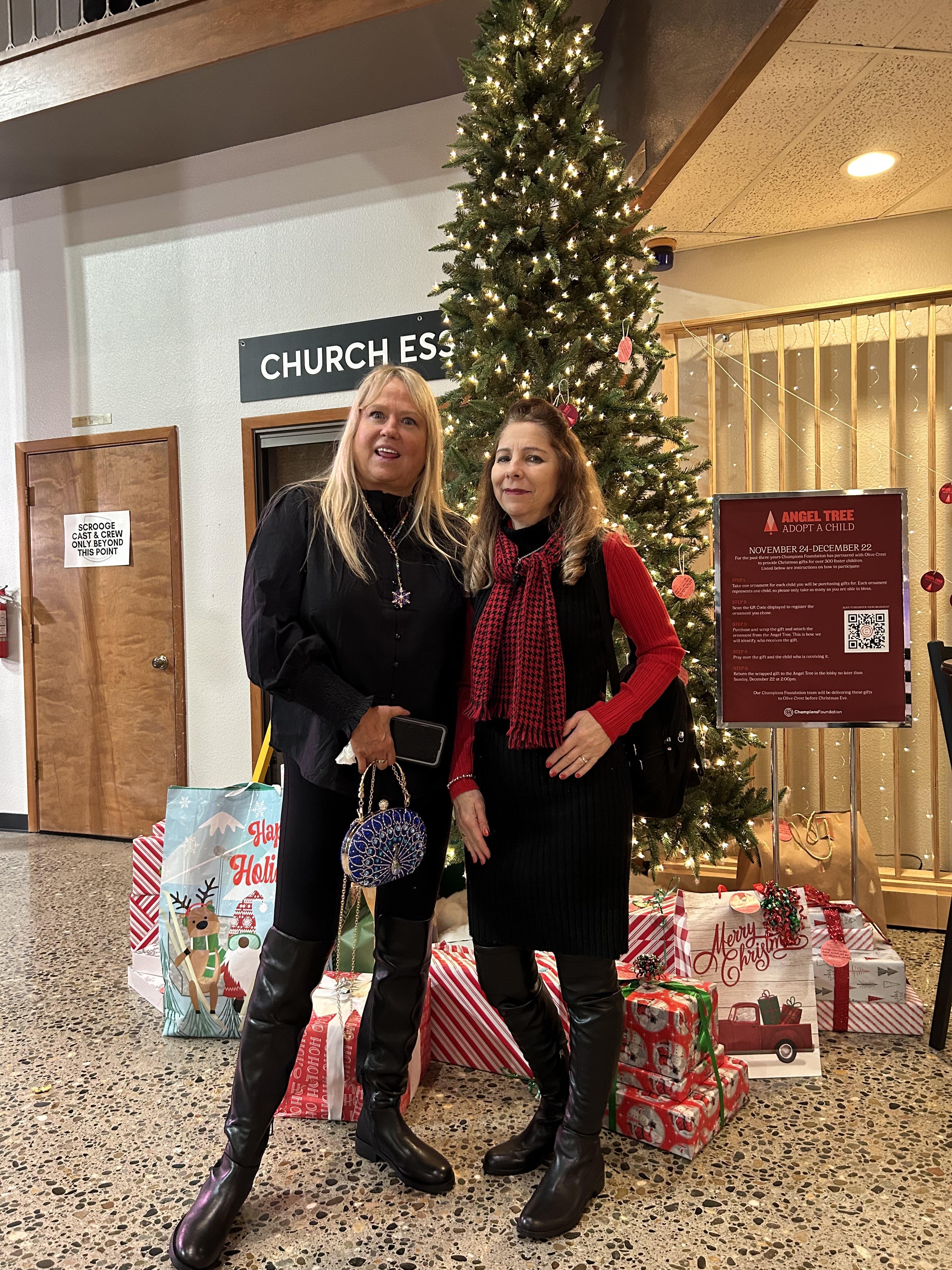 Two women standing in front of a christmas tree