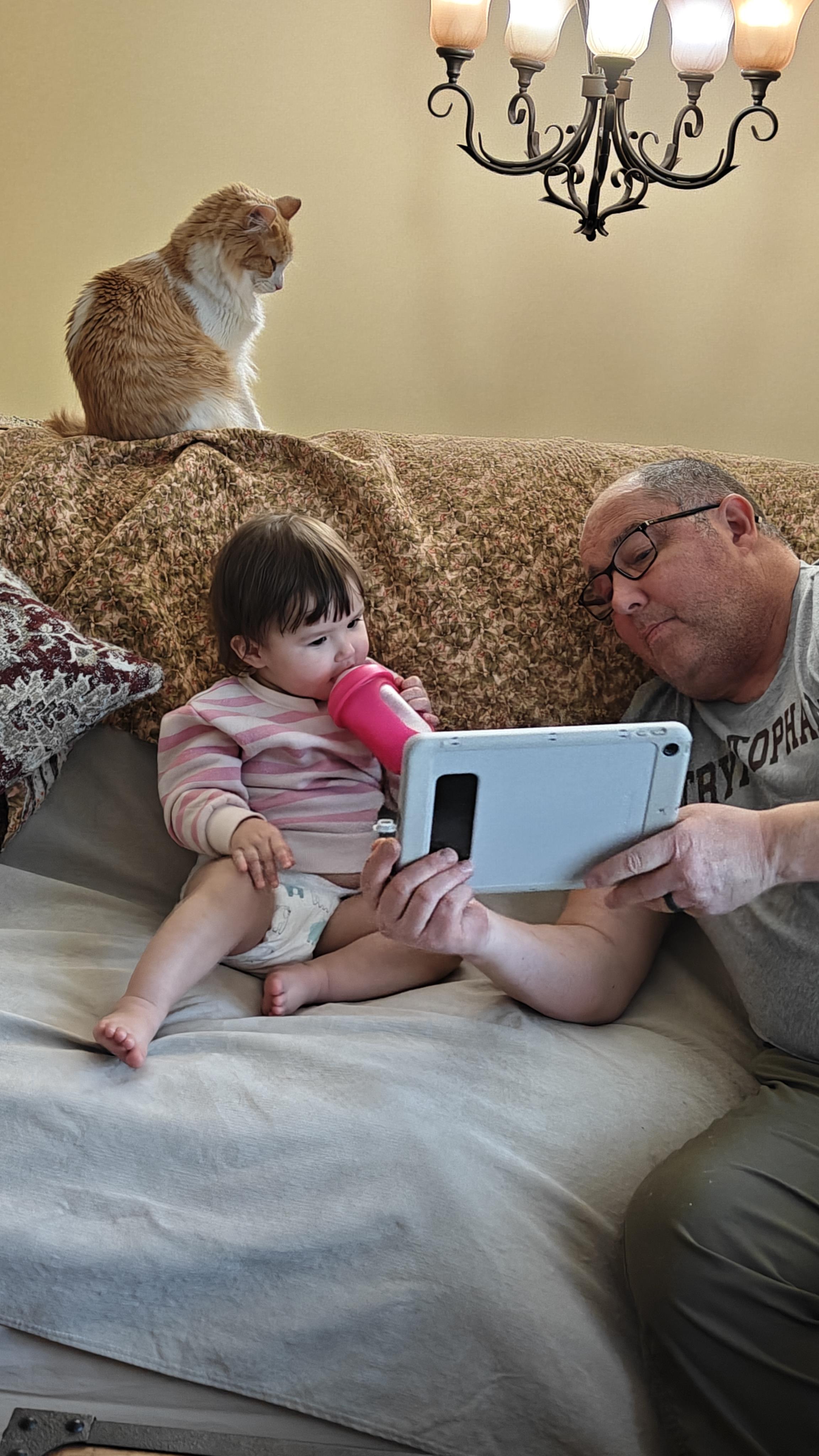 A man holding a tablet and a baby