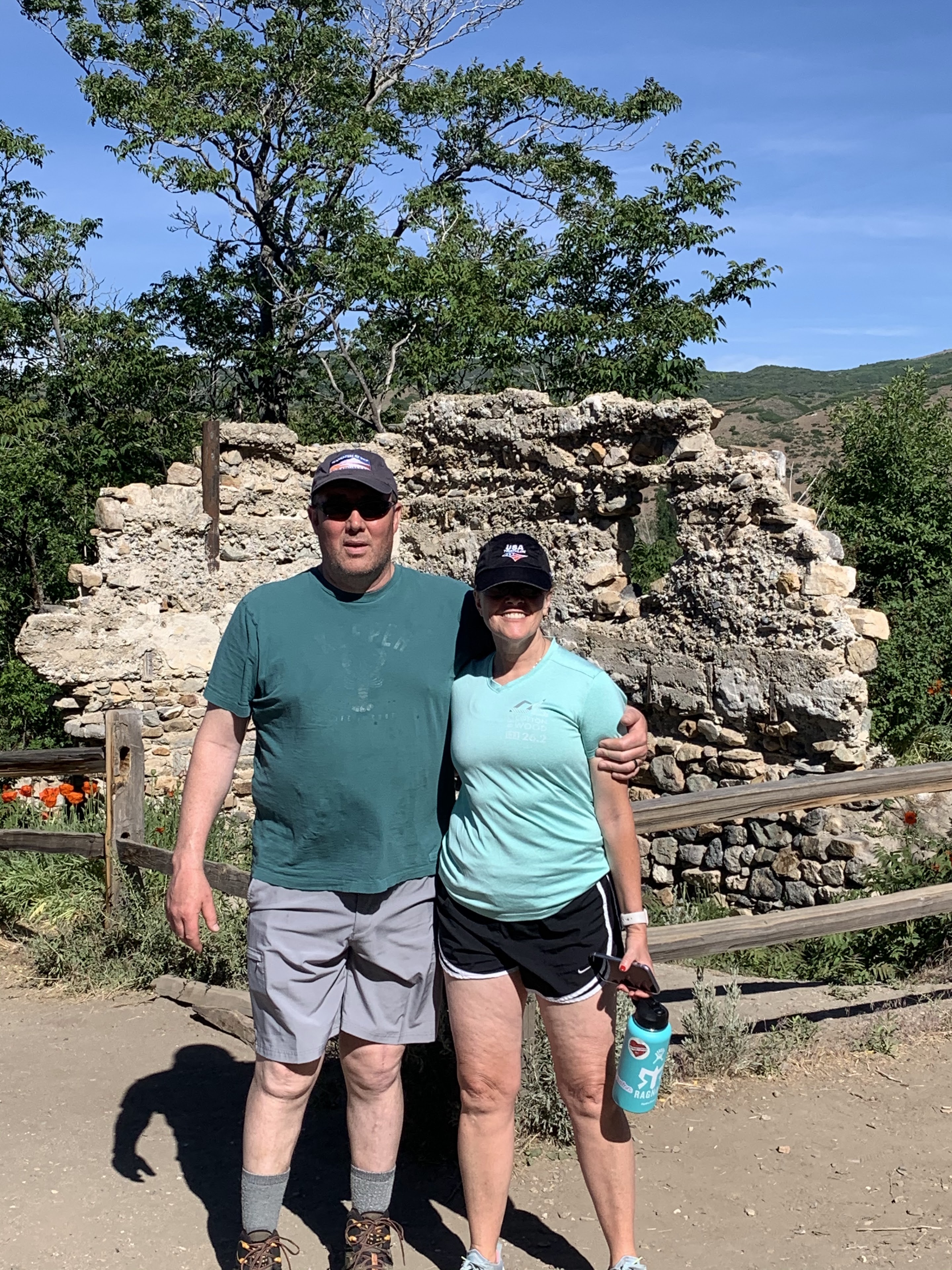 A man and woman standing in front of a stone wall