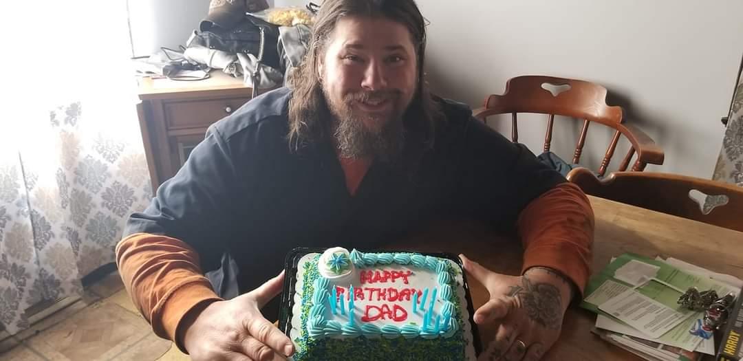 A man sitting in a chair with a cake