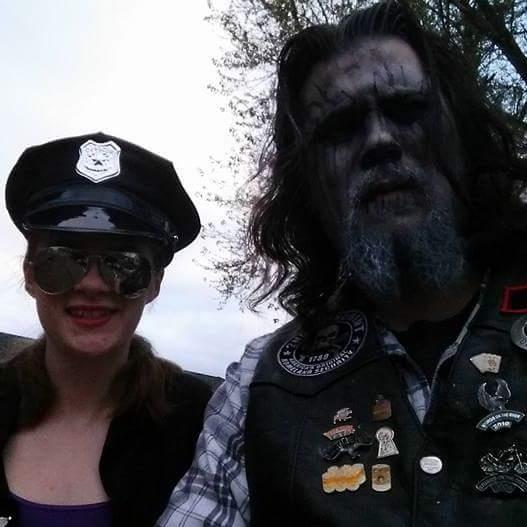 A man in a garment with a woman in a police hat