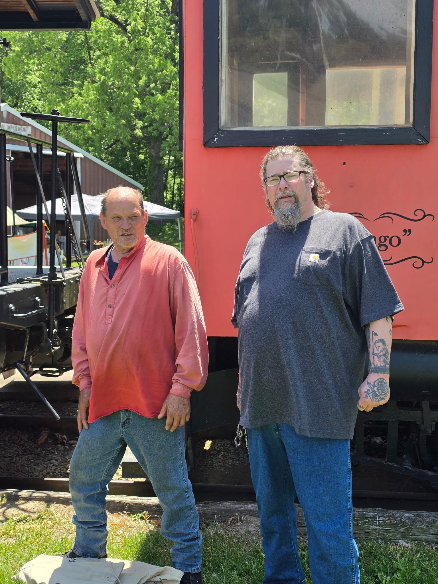 Two men standing in front of a train