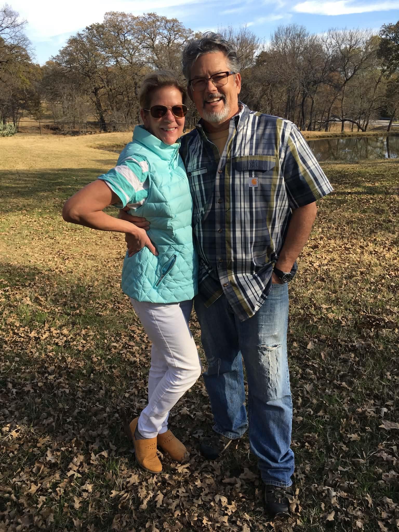 A man and woman standing together in a field
