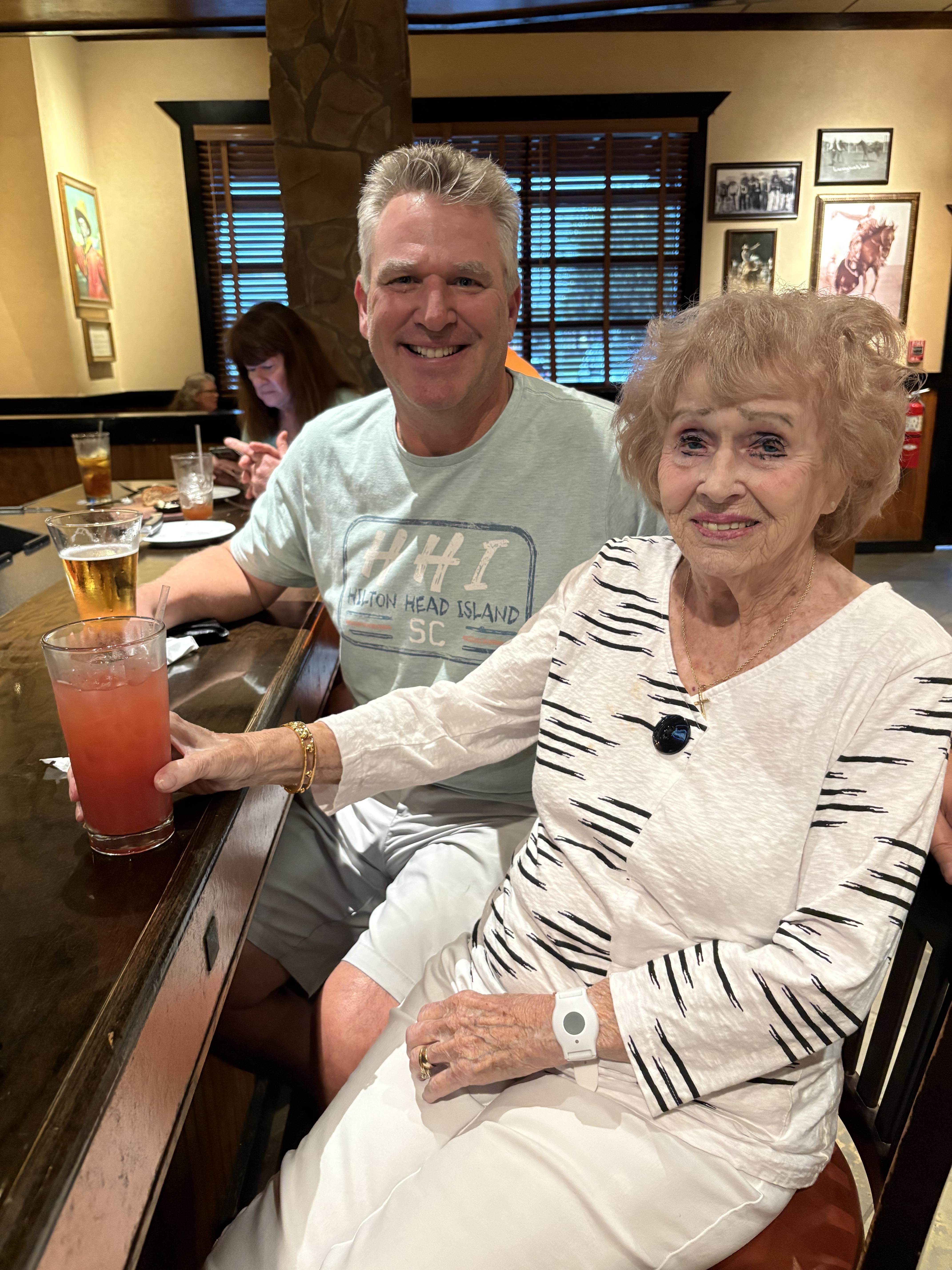 A man and woman sitting at a bar with drinks