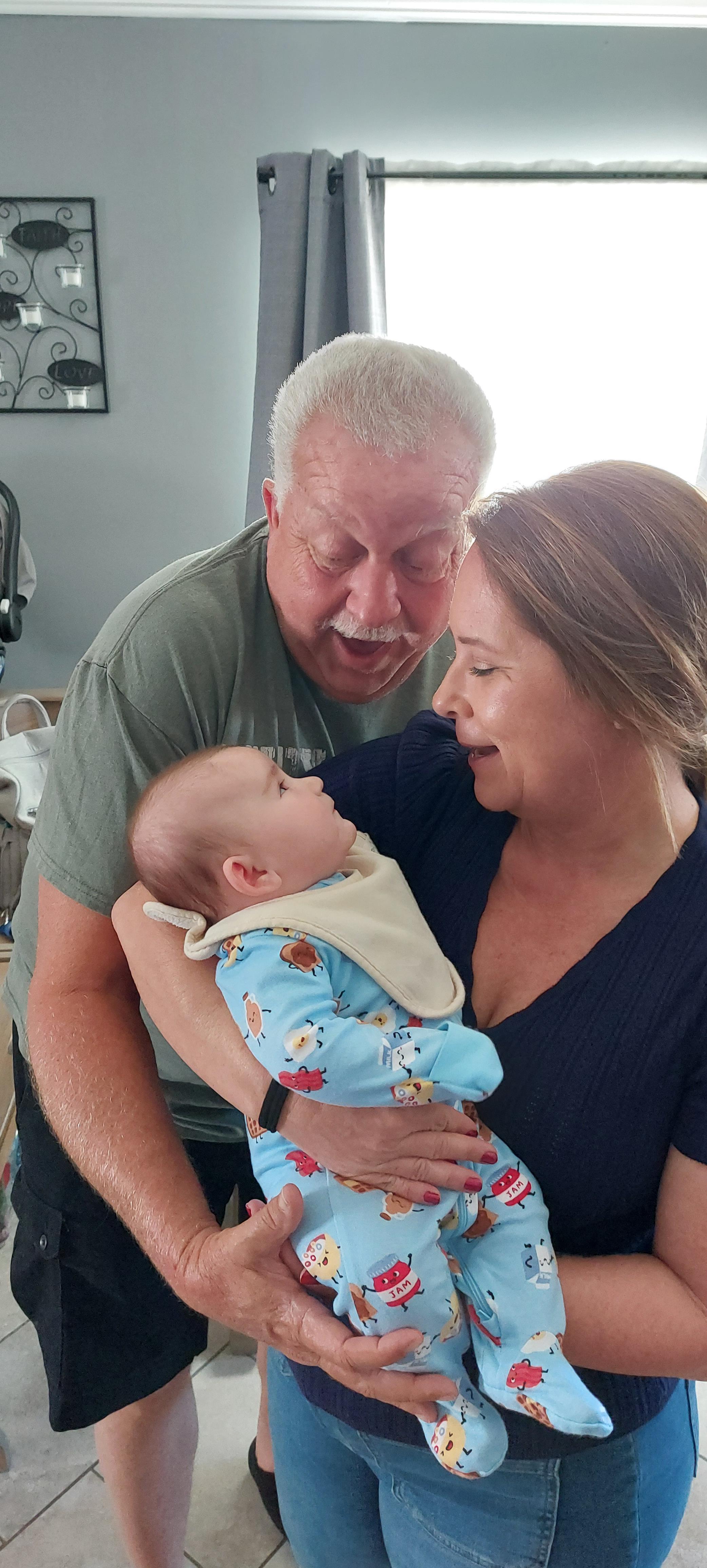 A man and woman holding a baby