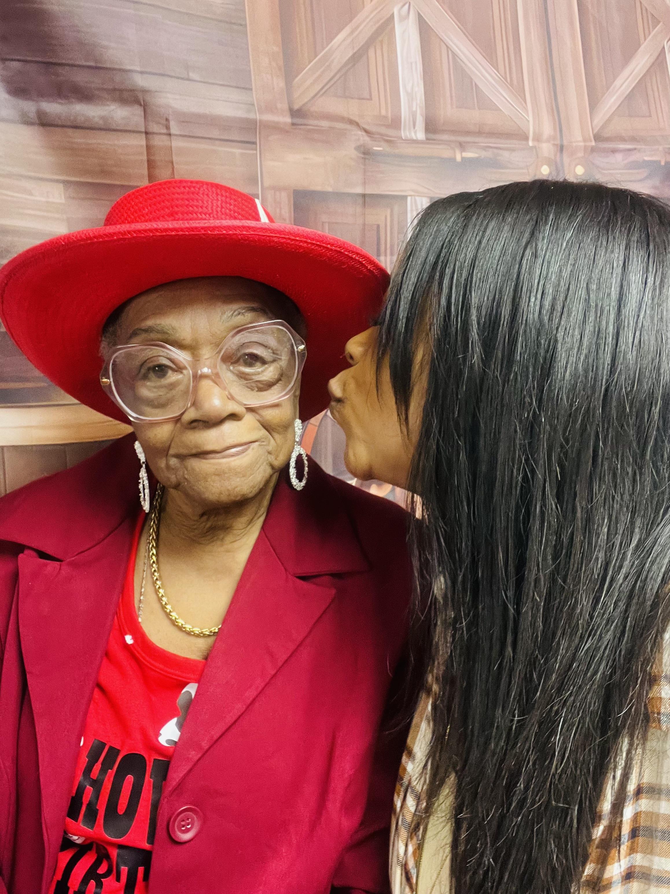 A woman kissing an older woman's cheek