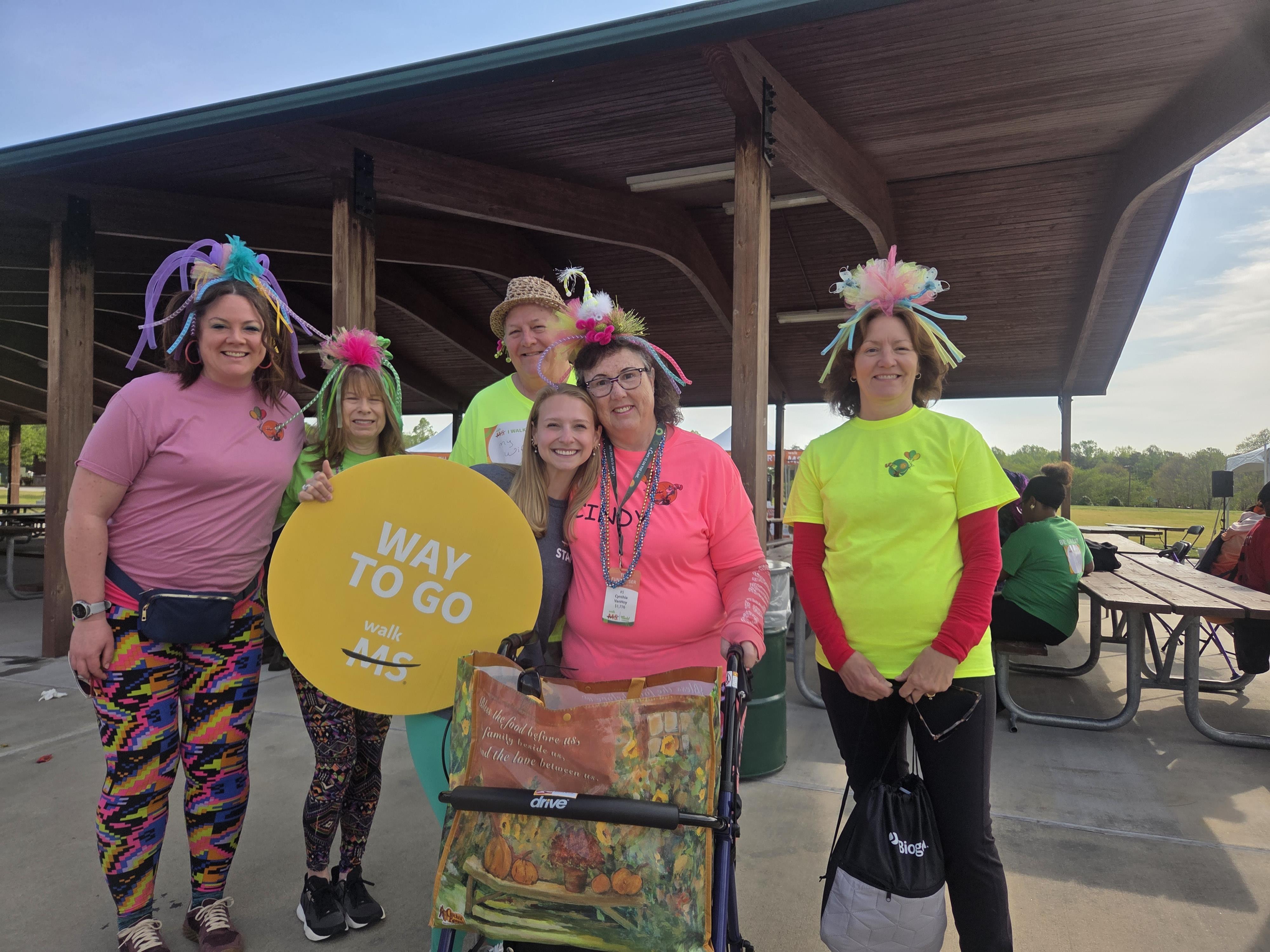 A group of women wearing colorful shirts and hats