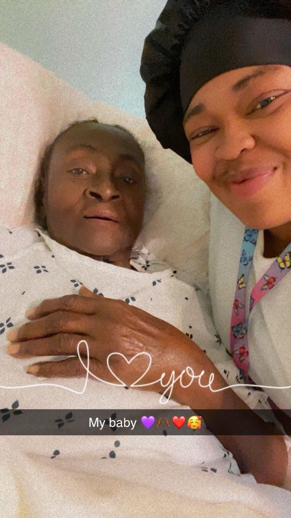 A woman lying in a hospital bed with a woman smiling