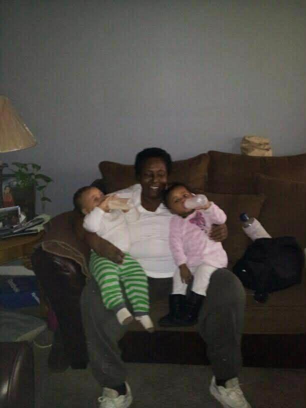A woman holding two babies