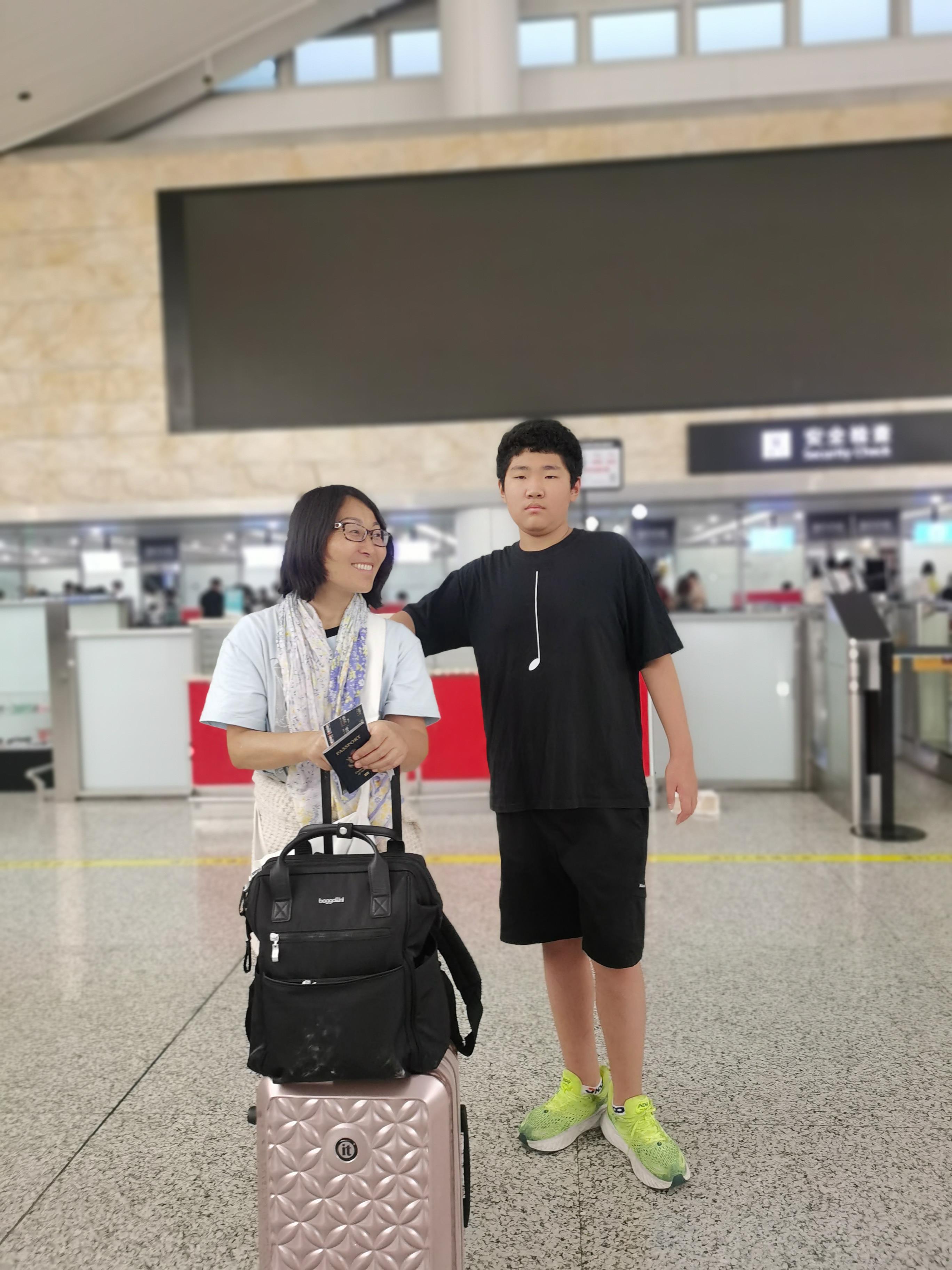 A man and woman standing next to each other with luggage