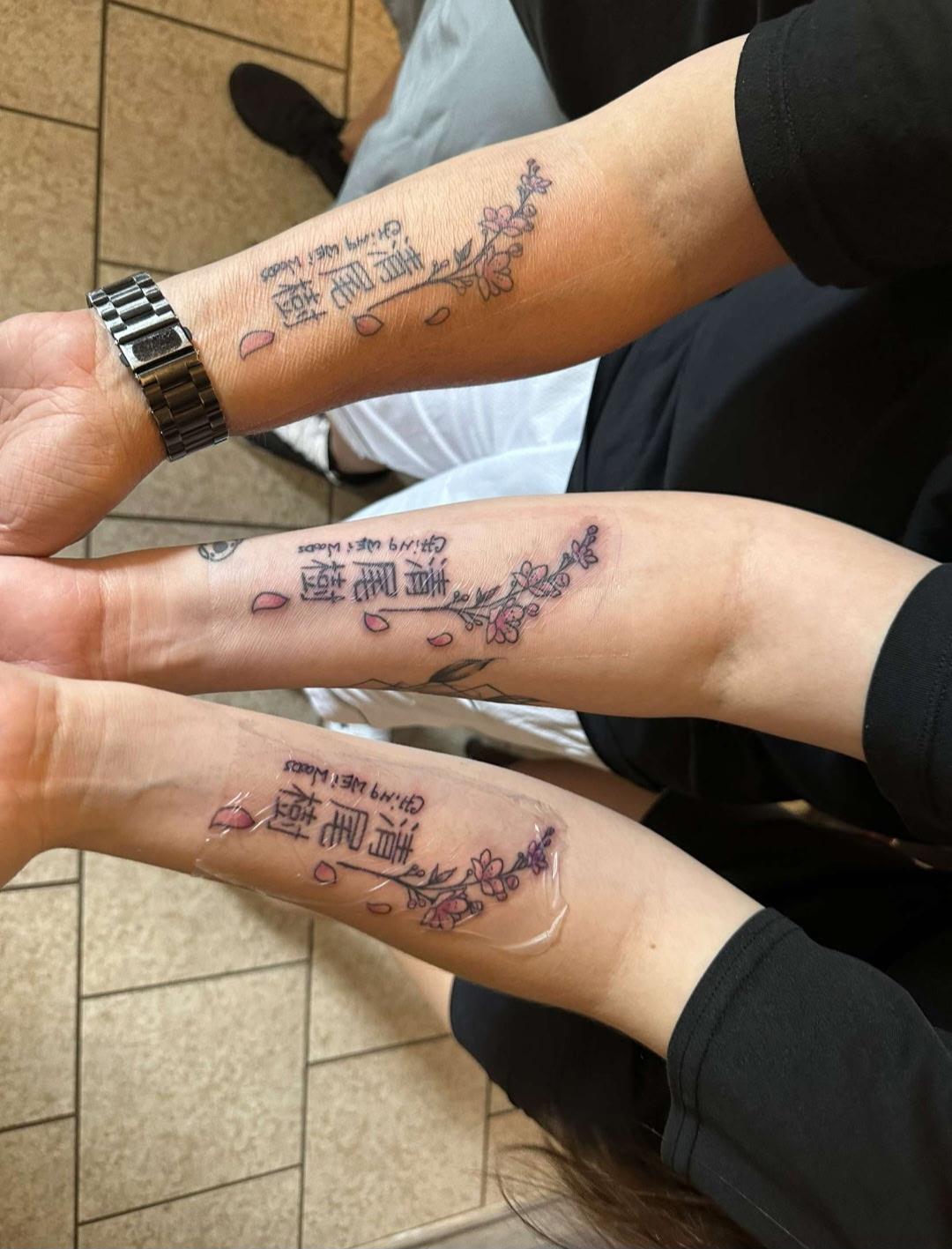 A group of people's hands with tattoos