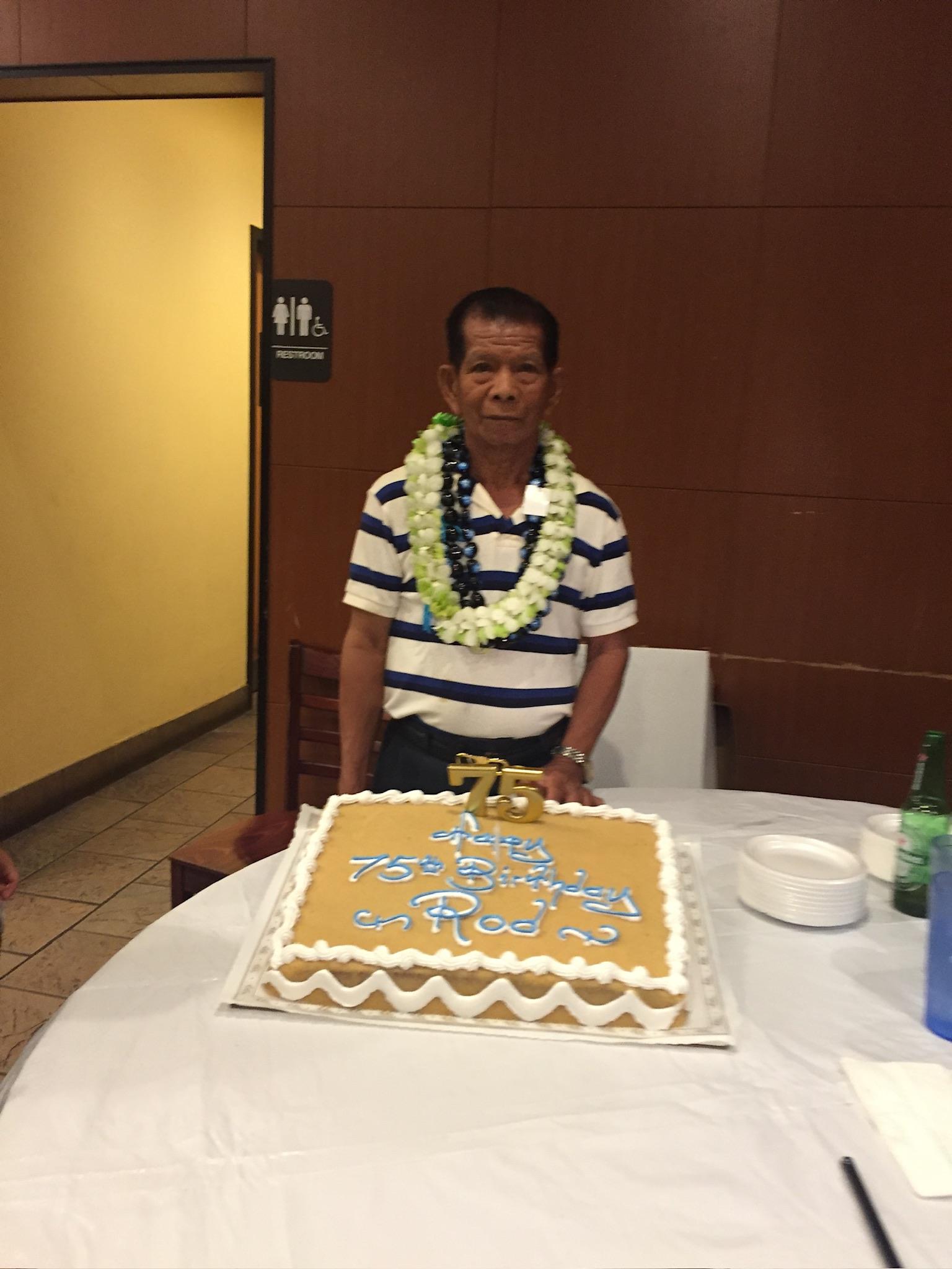 A man sitting at a table with a cake