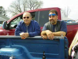 A couple of men in the back of a pickup truck