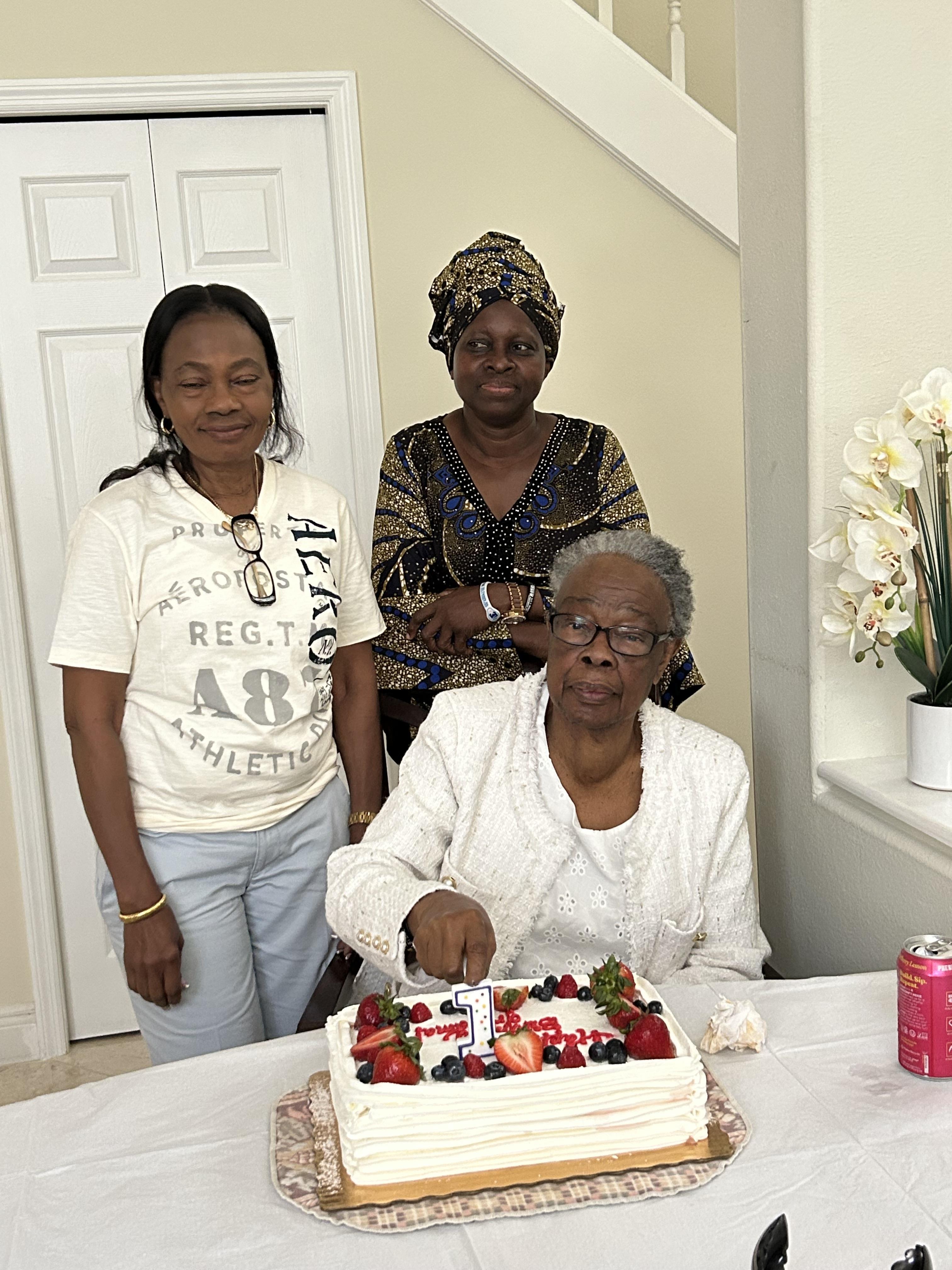 A group of women standing around a cake