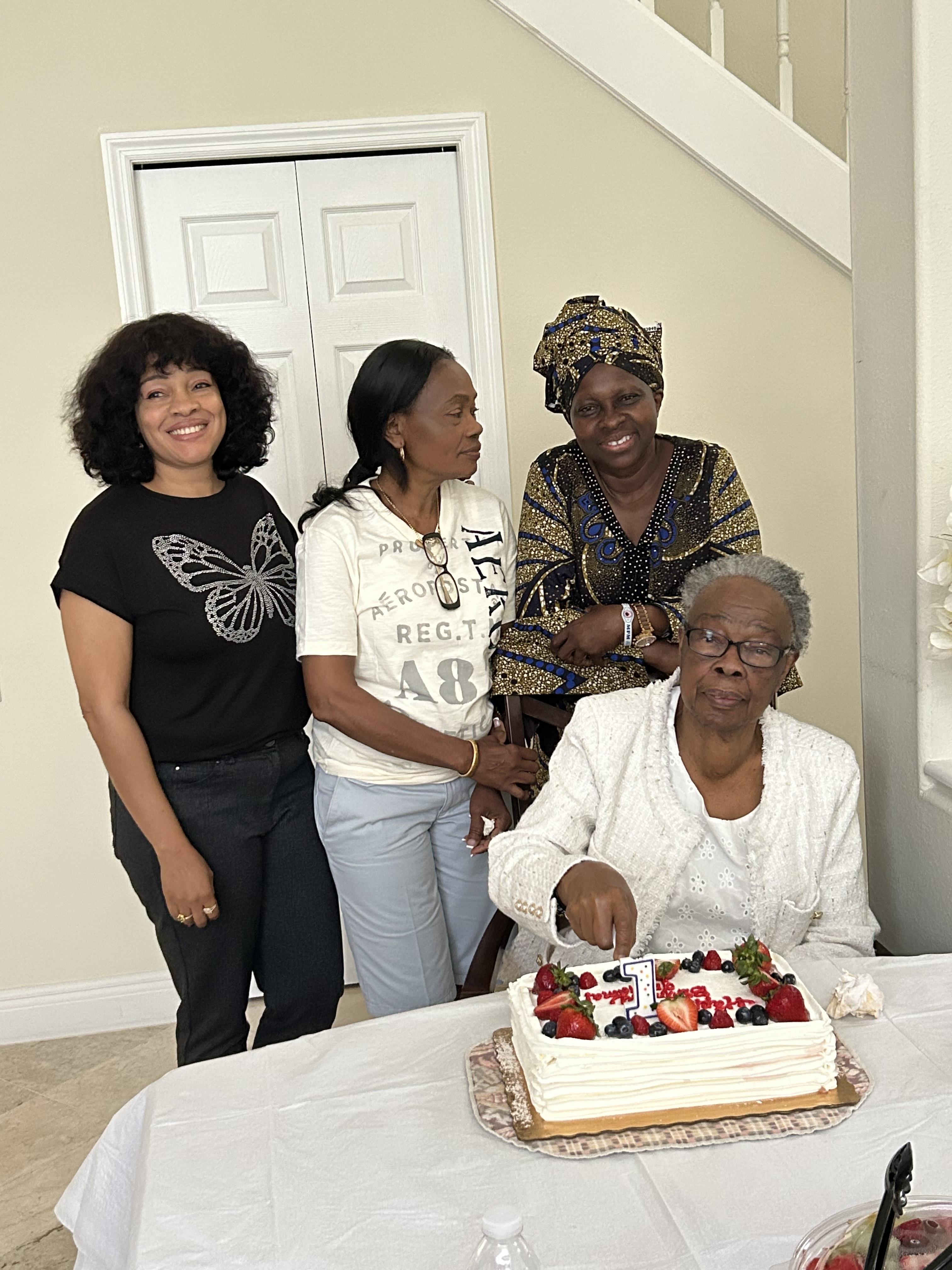A group of women standing around a cake