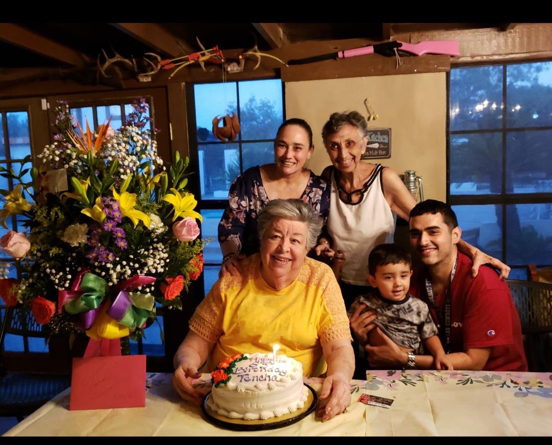 A group of people around a cake