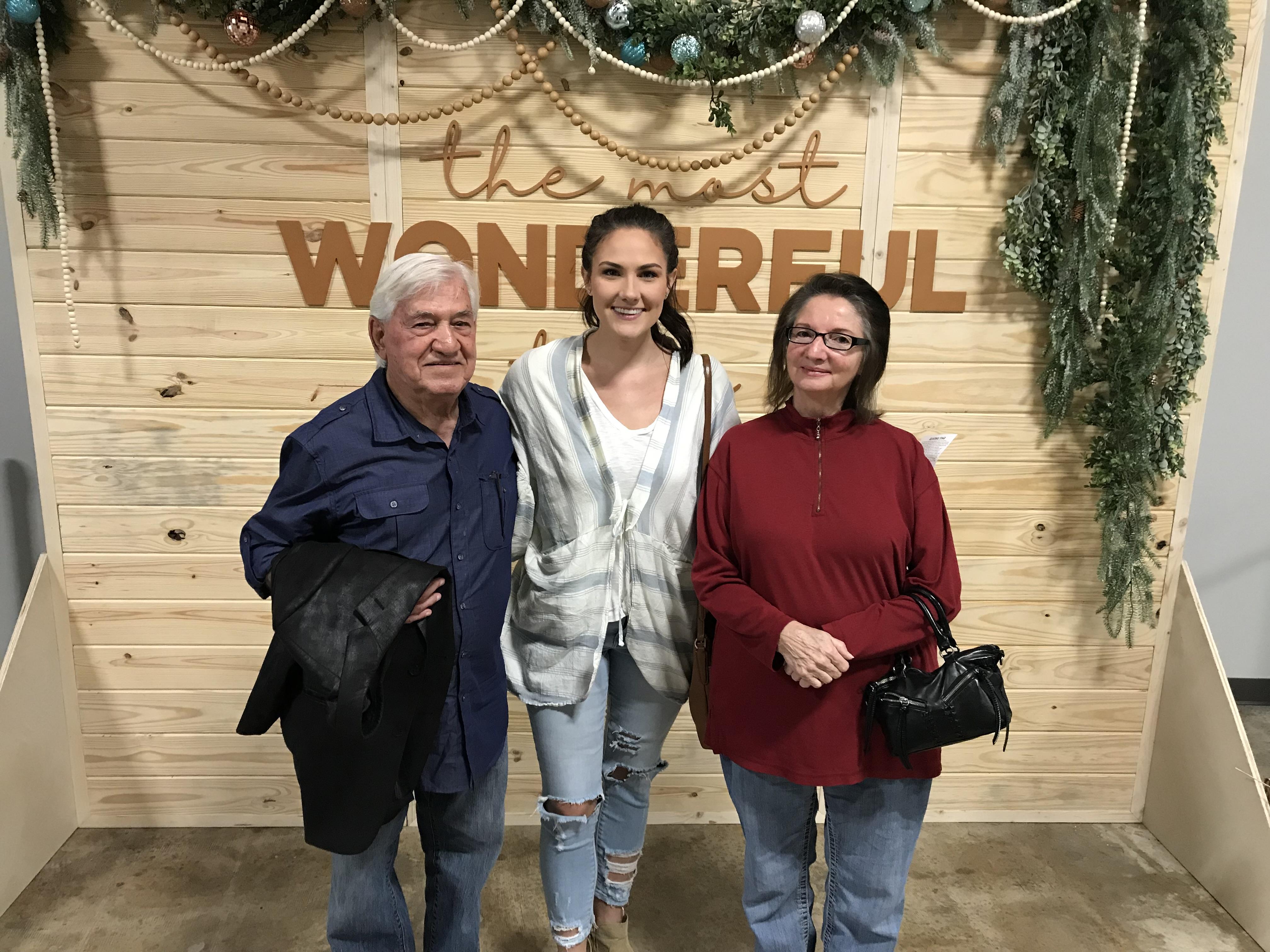 A group of people standing in front of a sign