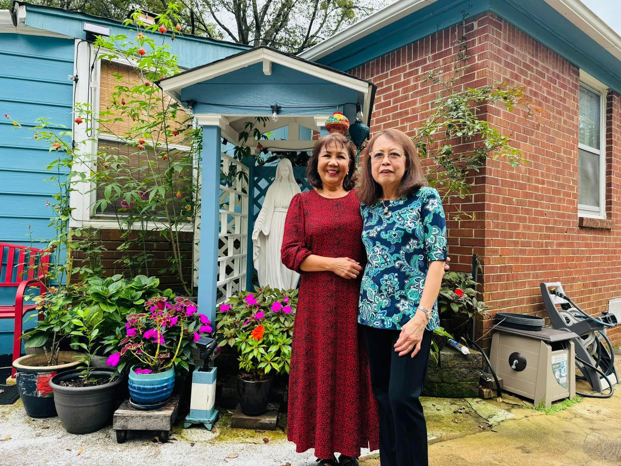 Two women standing in front of a house