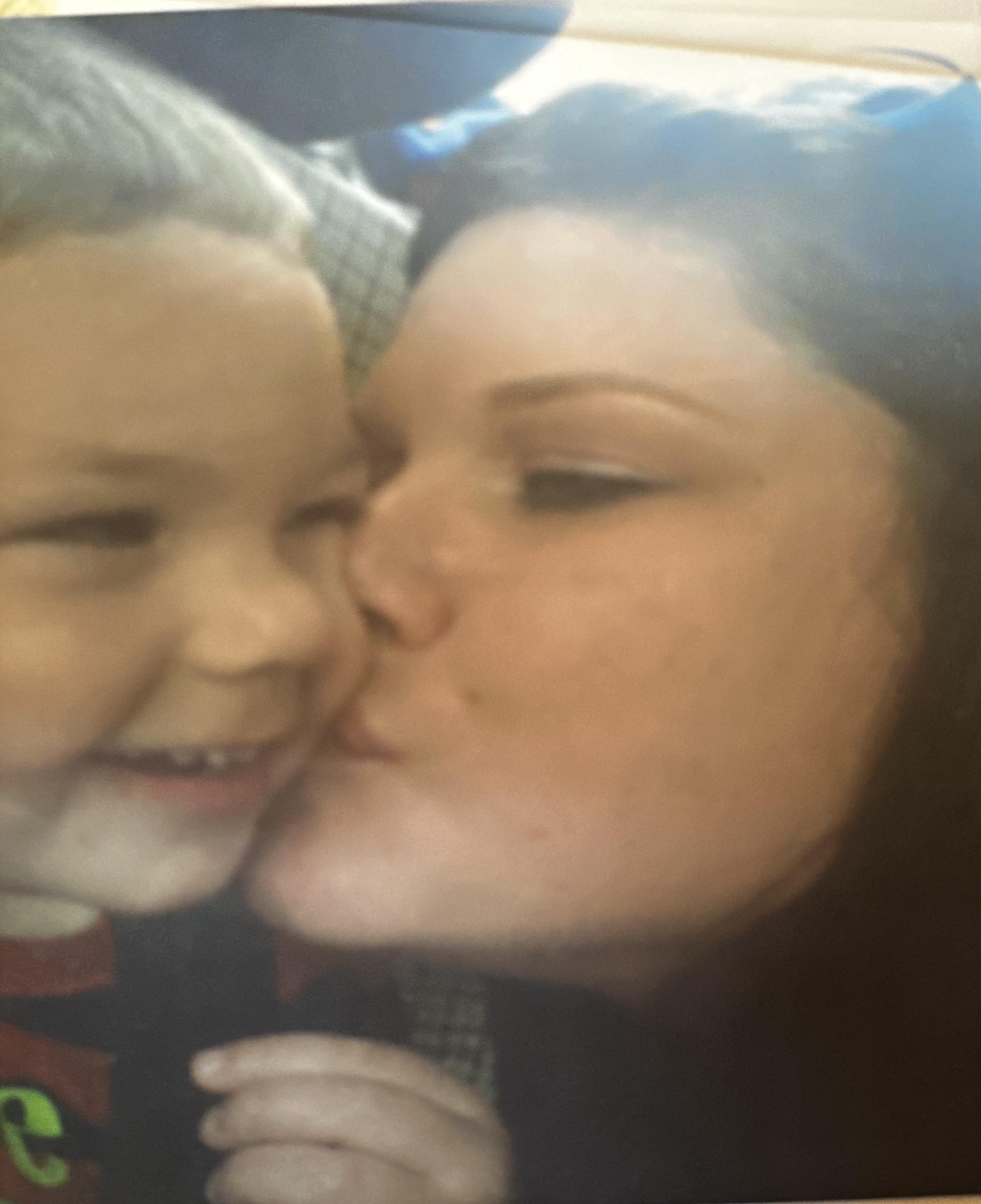 A woman kissing a child