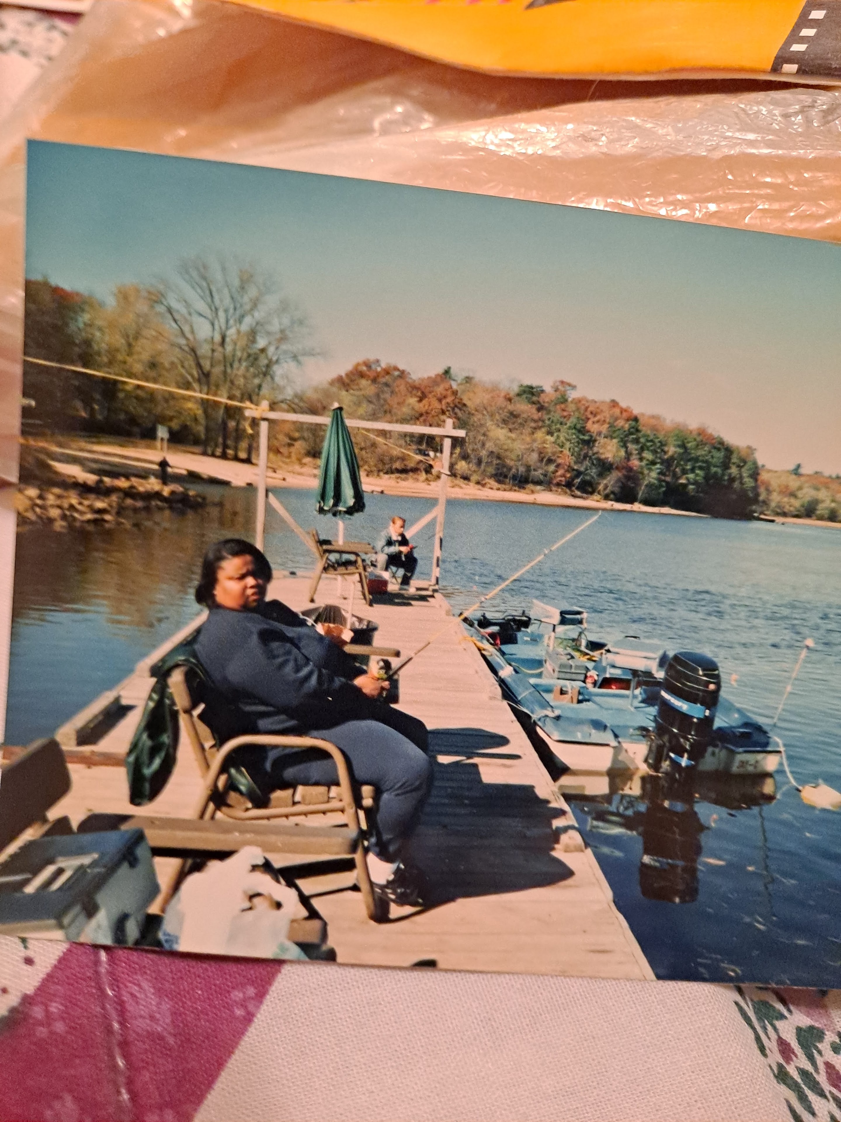 A woman sitting on a dock with boats on the water