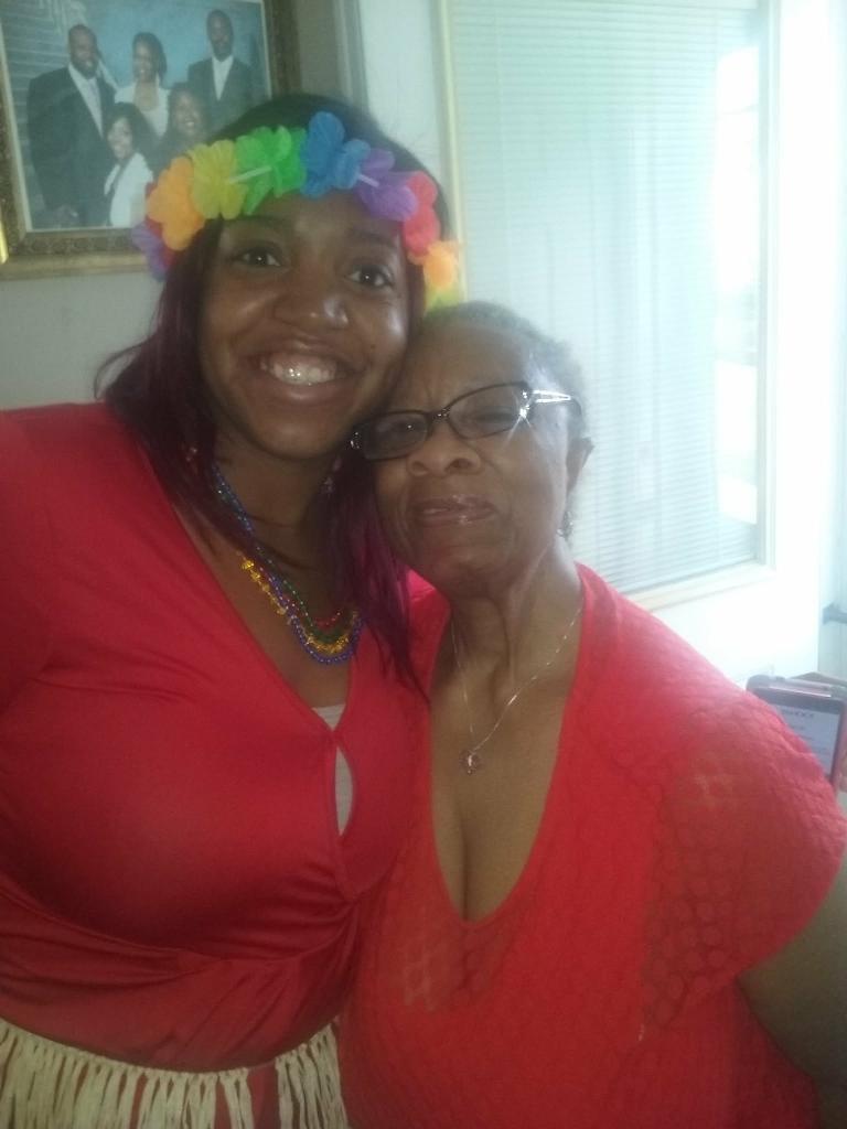 A woman with a rainbow headband and a woman with glasses