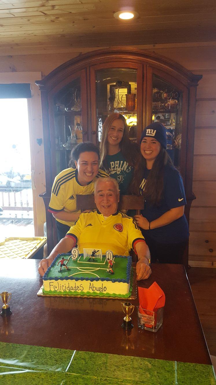 A man sitting in a chair with a cake with a football player on it