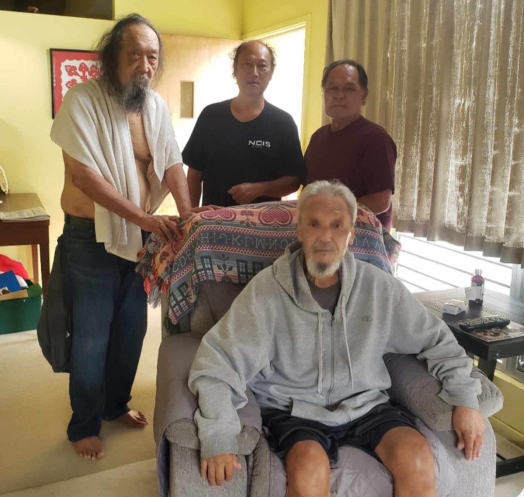 A group of men standing around a couch