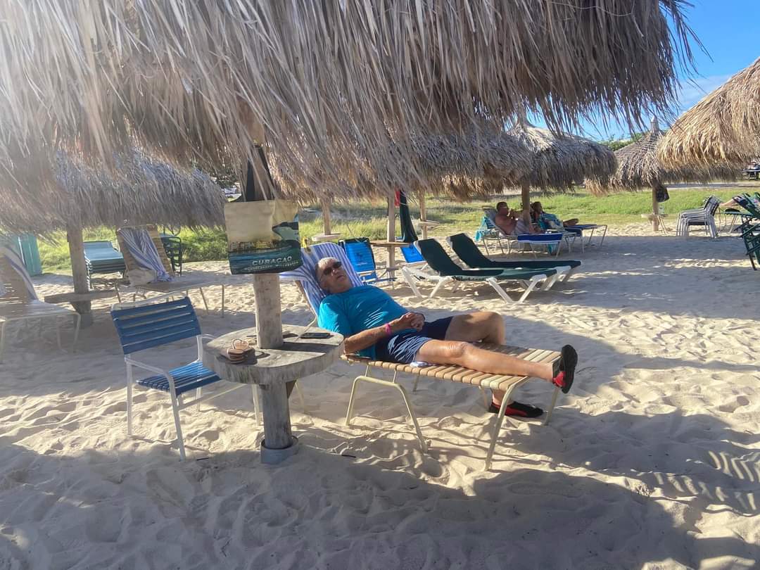 A man lying on a chair on a beach