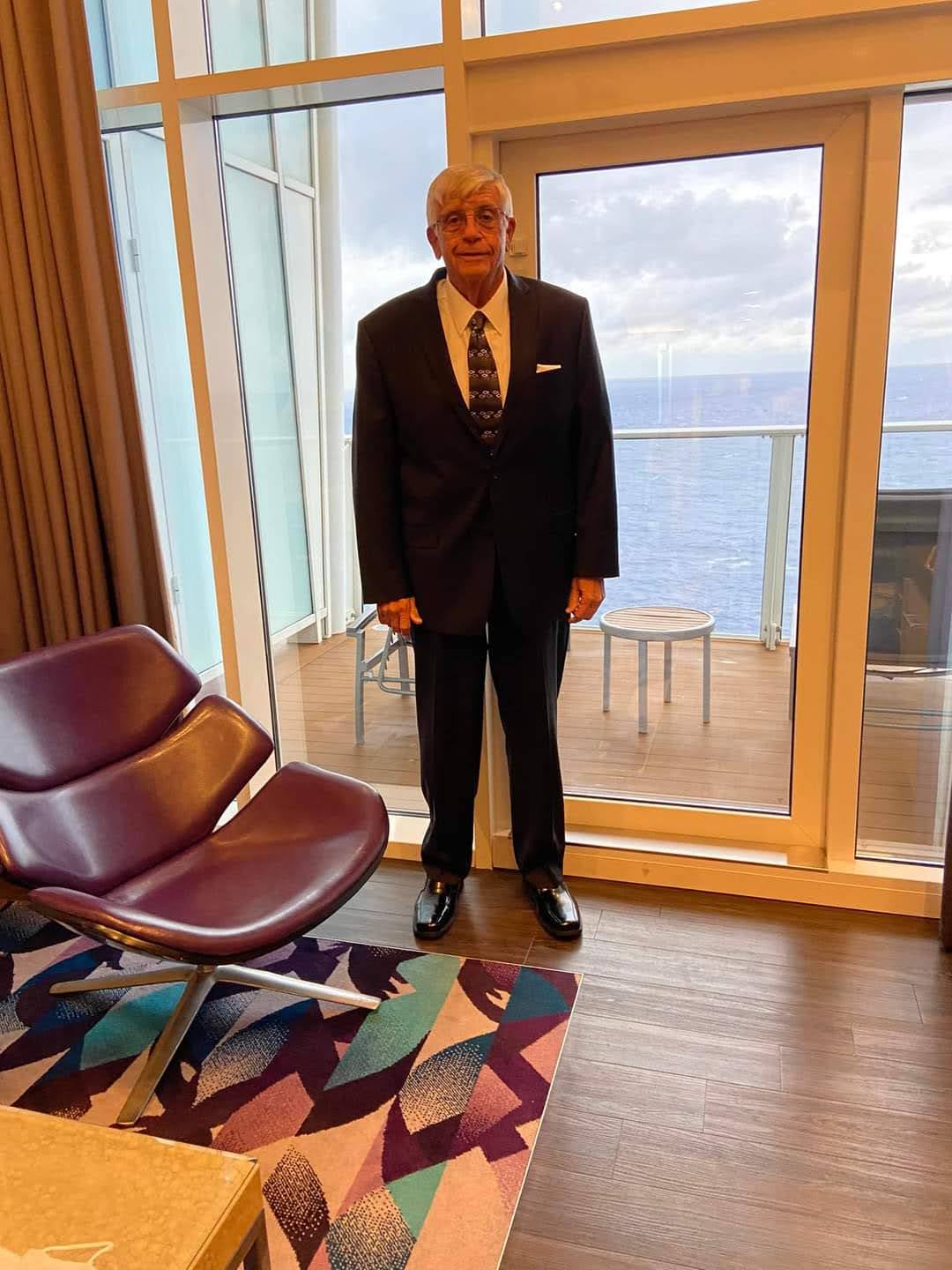 A man in a suit standing in front of a glass door