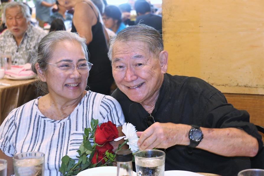 A man and woman sitting at a table with flowers