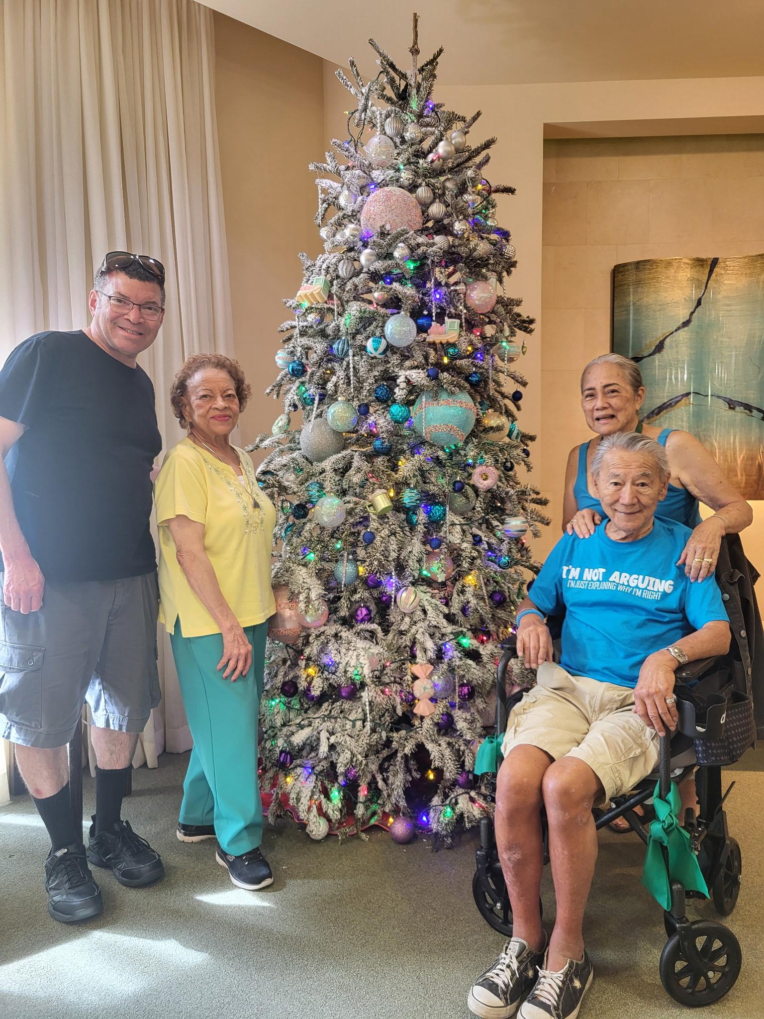A group of people posing for a photo with a christmas tree