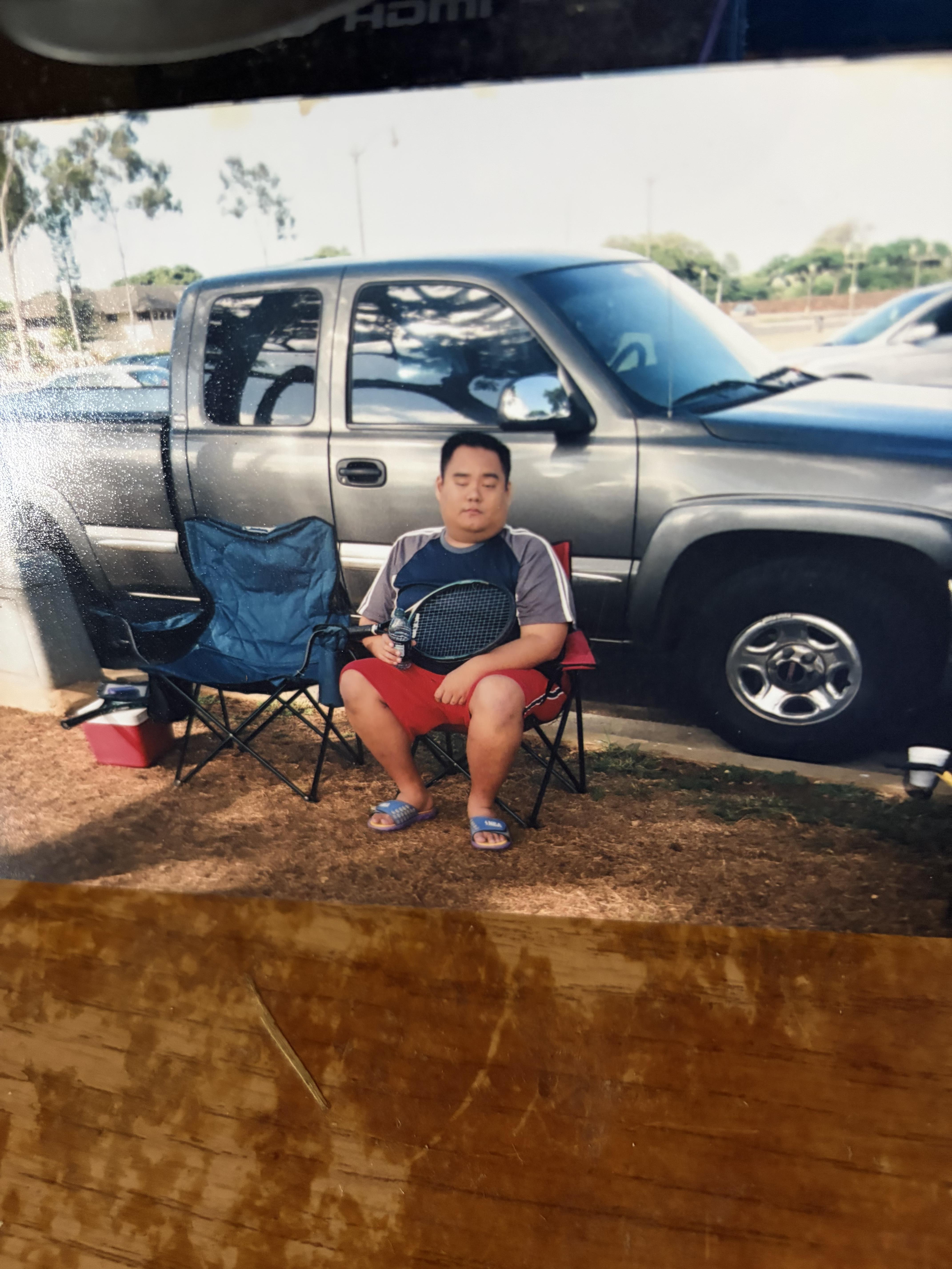 A man sitting in a chair next to a truck