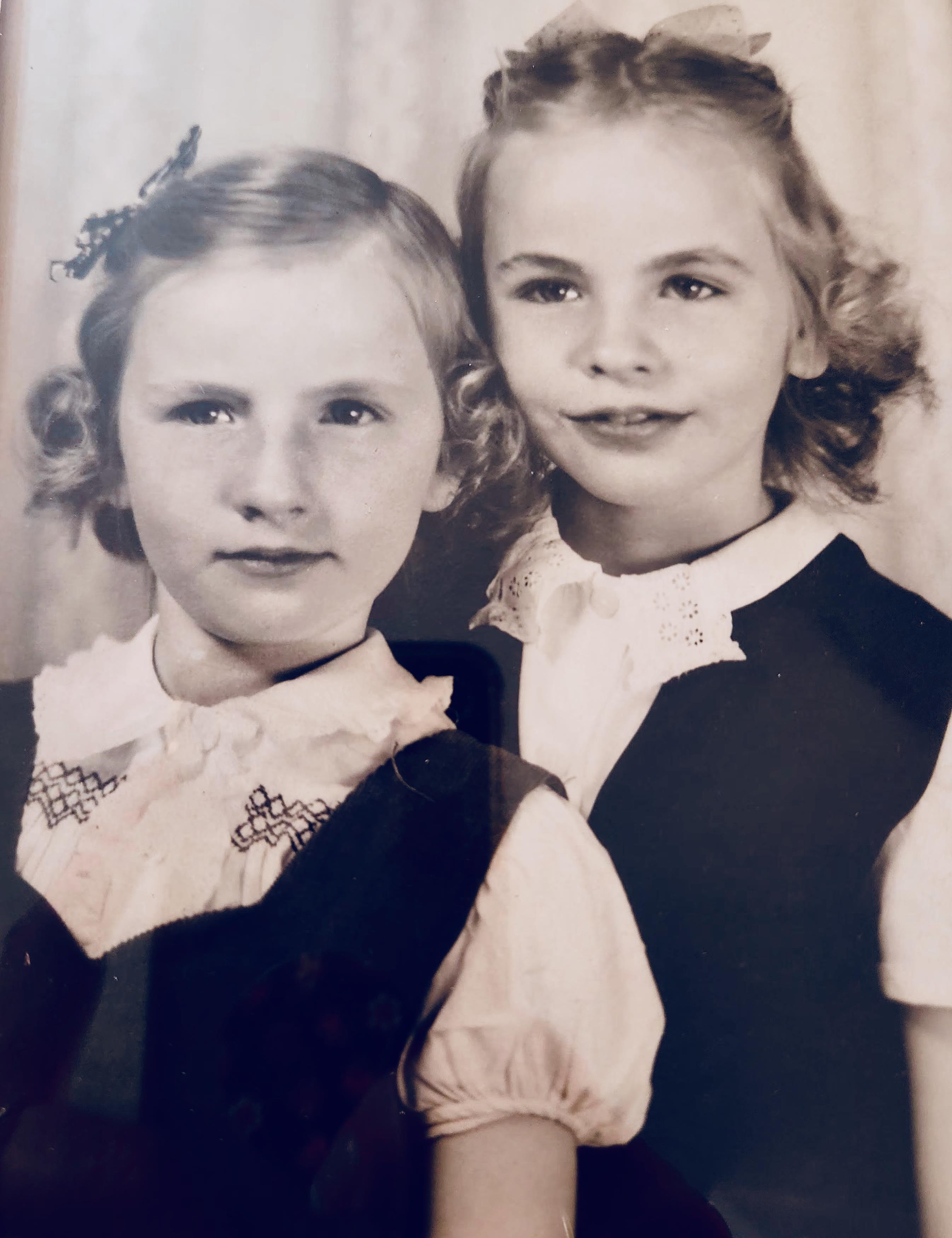 A couple of young girls posing for a picture